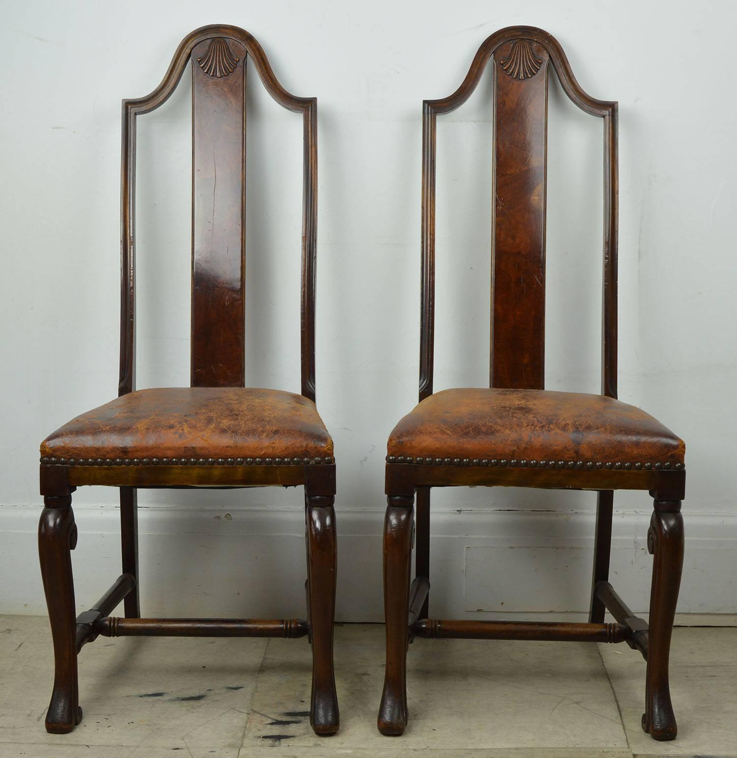 Great pair of walnut side or hall chairs in Baroque style.

Fabulous colour of wood and leather.

Finely carved shell detail on the top of the burl walnut splats.

Also a lovely ammonite shaped carved detail on the top of the front legs.

Original