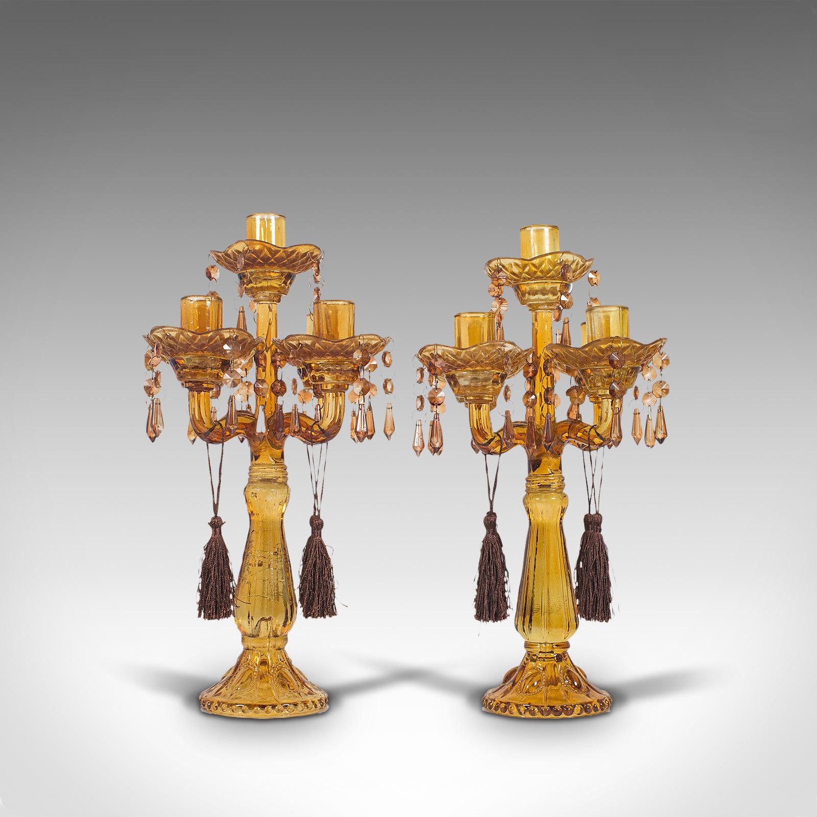This is a pair of antique candelabra. An English, amber glass four branch table lustre or candle stand, dating to the late Victorian period, circa 1890.

Stunning color invites the eyes
Displaying a desirable aged patina - glass in good
