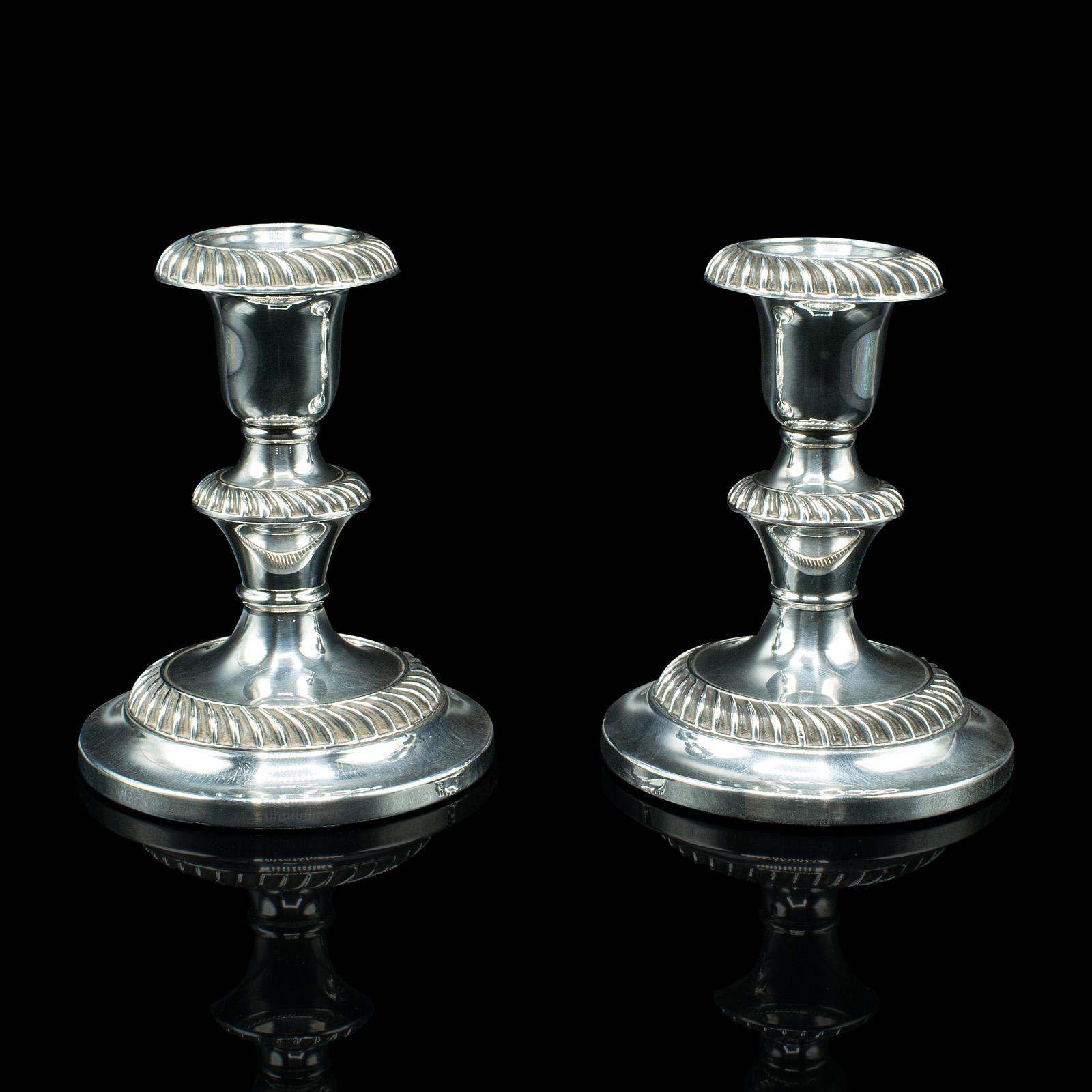 This is a pair of antique candlesticks. An English, silver plate candle sconce, dating to the Edwardian period, circa 1910.

Elegant candlesticks with bright appearance and fine detail
Displaying a desirable aged patina throughout
Superb, reflective