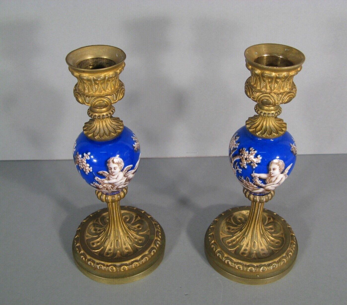 This charming pair of antique candlesticks is crafted in patinated bronze and painted porcelain, embodying a Romantic style with delightful motifs of putti and floral elements.

Material: Bronze (patinated) and painted porcelain
Decor: Putti