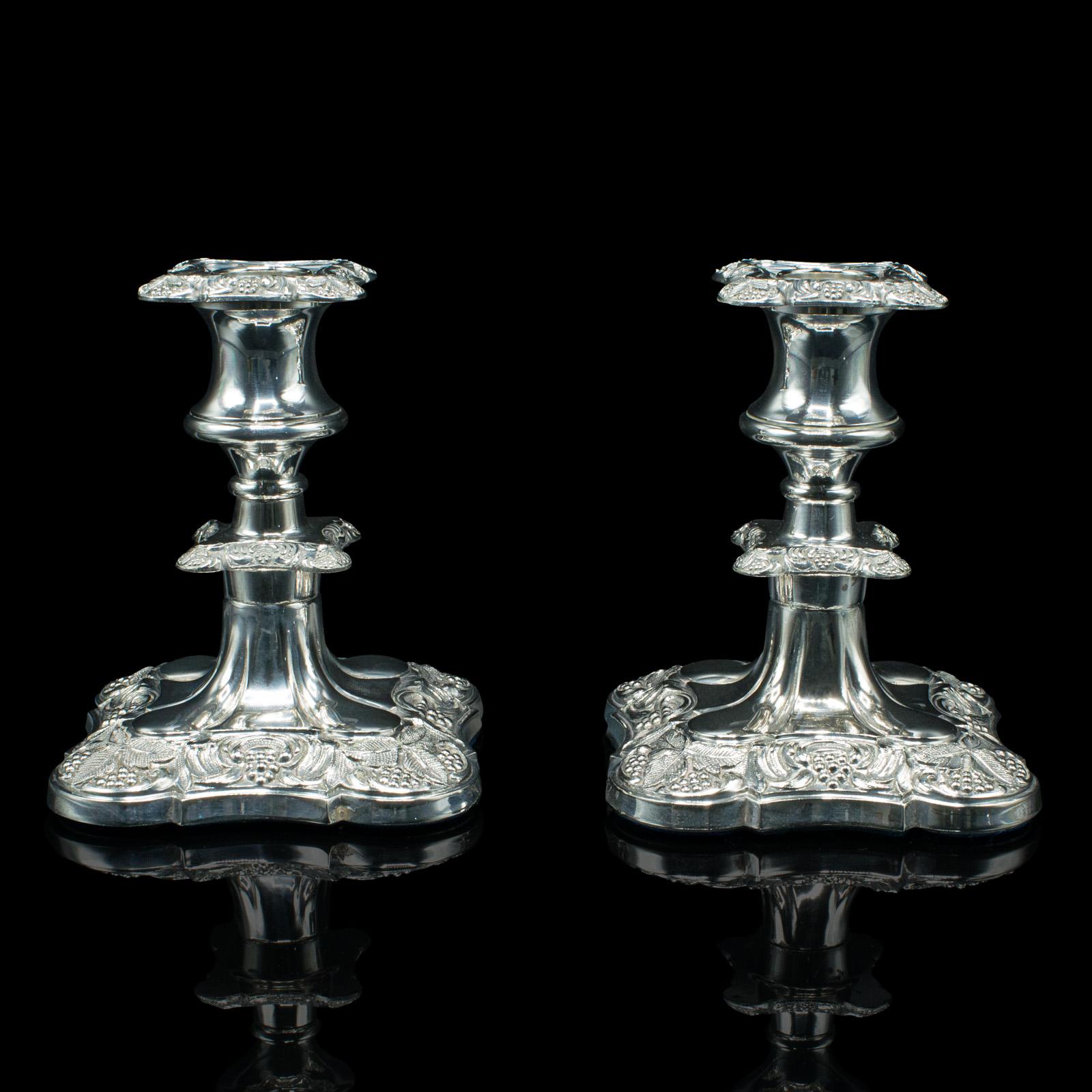 This is an antique pair of candlesticks. An English, silver plated decorative candle holder, dating to the late Victorian period, circa 1900.

Appealing late Victorian pair with fine detail and elegant craftsmanship
Displaying a desirable aged