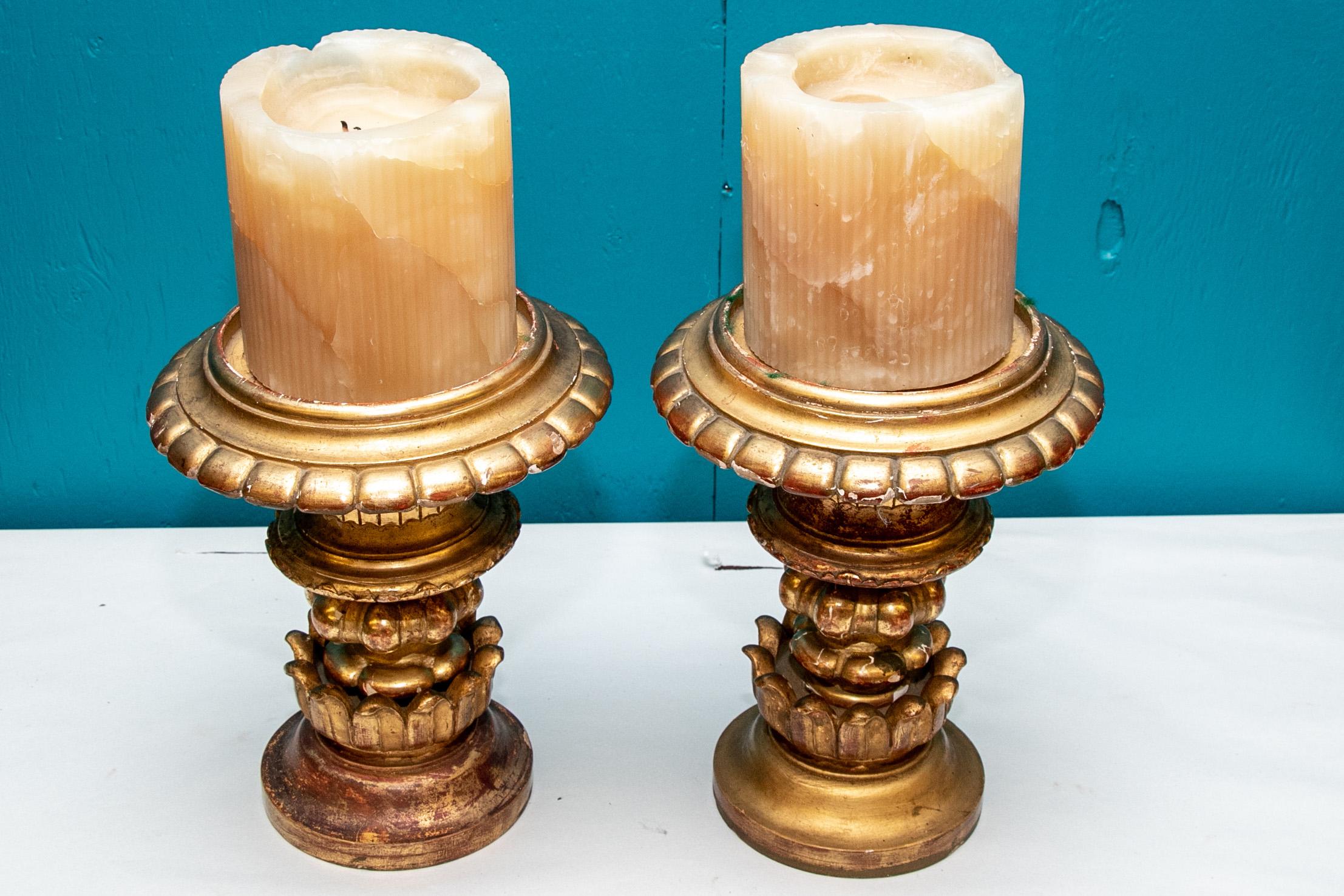 Pair of antique carved and gilt candle stands, tiered neoclassical forms with wide round tops carved with bosses and leaves. Carved, gessoed and gilt. 

Condition: Expected signs of use including some chips to gilt.