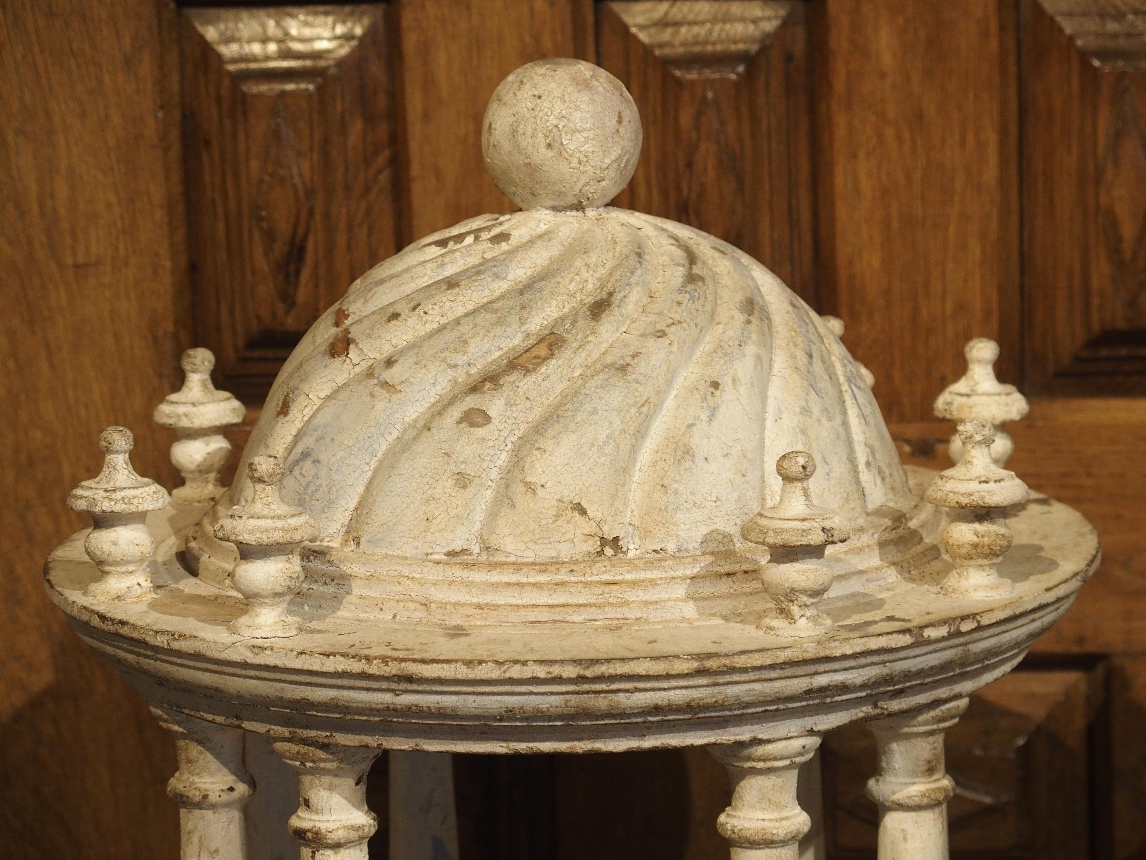 These parcel paint Italian colonnades are almost identical, except for their roof motifs and finials. One has a swirling design with a ball finial and the other has linear half rounds with a pine cone finial. Each has the same eight pillar