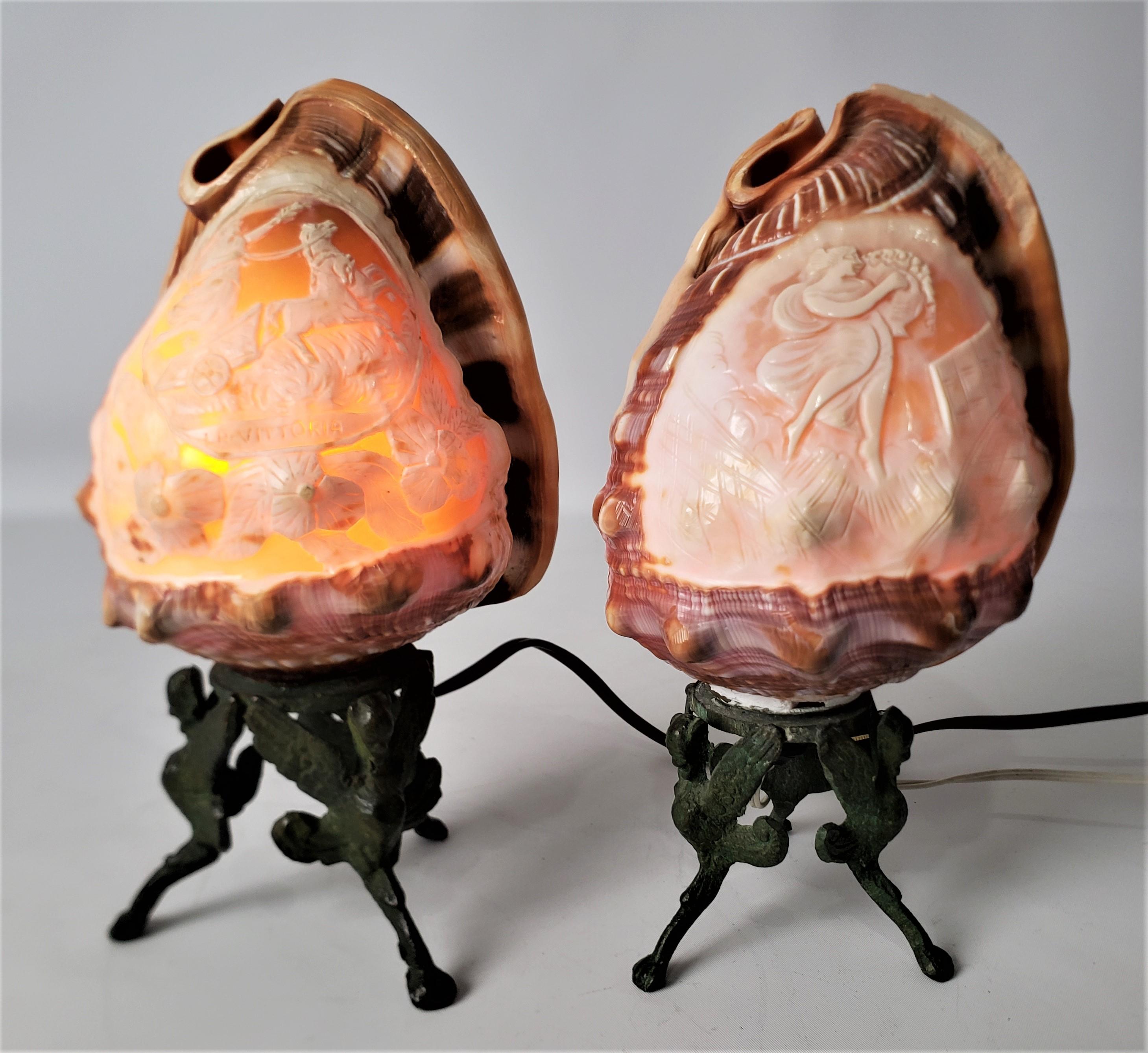 These antique carved shell accent lamps are unsigned, but presumed to have originated from Italy and dating to approximately 1920 and done in a Renaissance Revival style. The lights are natural conch style shells which have been elaborately