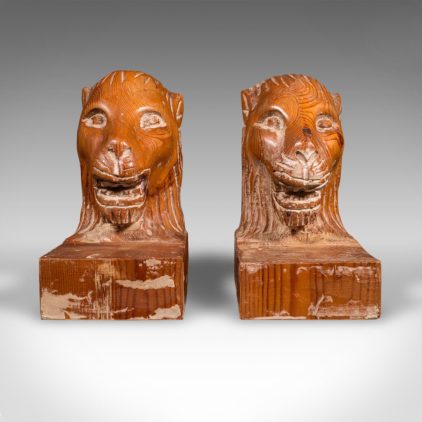 This is a distinctive pair of antique carved lion bookends. An English pine book rest presented in Georgian revival taste, dating to the Edwardian period, circa 1910. A charming and robust set, with wonderfully naive appeal.

Hand-carved lion head