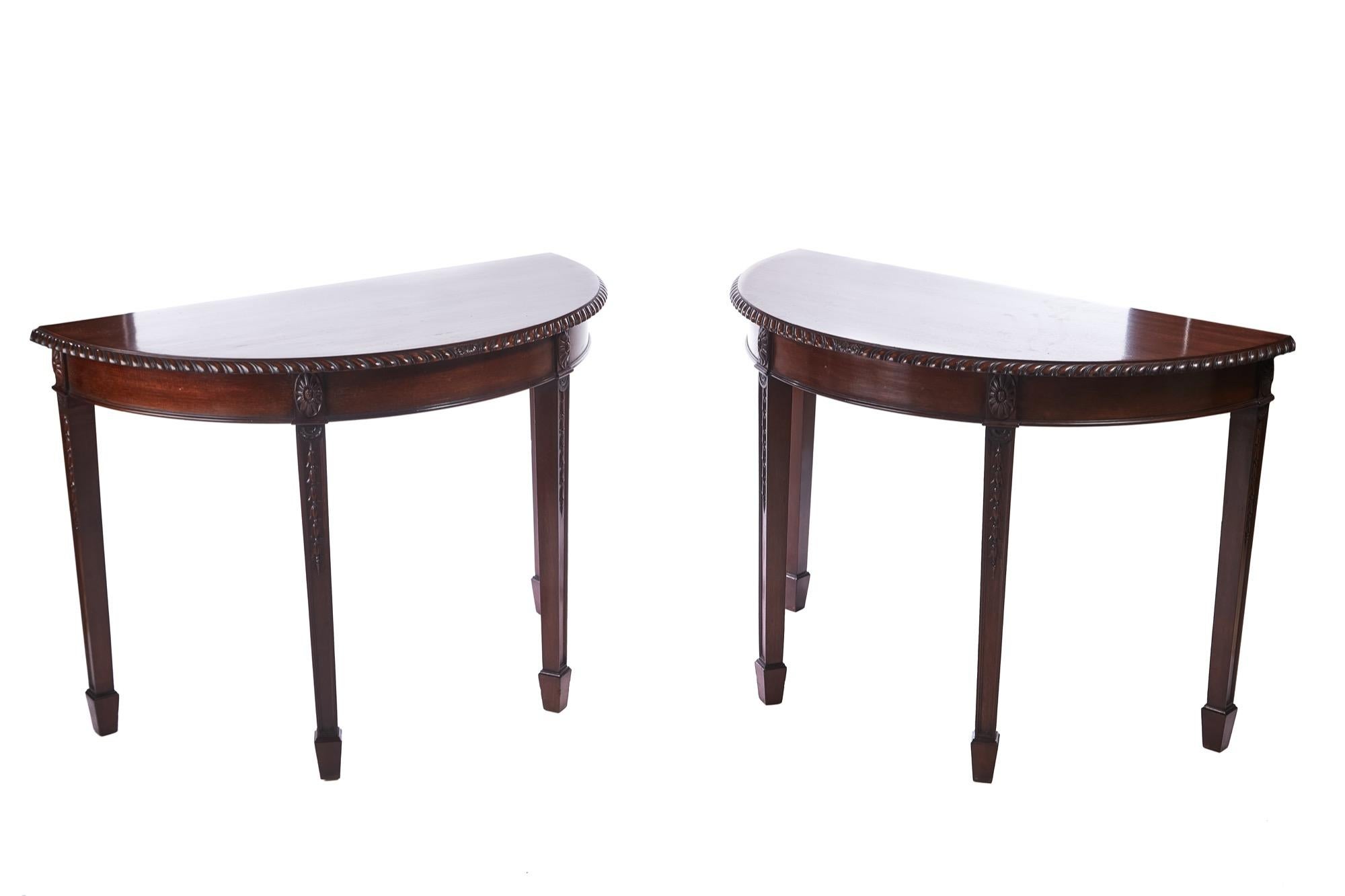 Pair of antique carved mahogany demilune console tables having lovely mahogany tops with a carved edge. Shaped apron standing on 4 carved reeded square tapering legs with spade feet.
Lovely color and condition.
Measures: 42