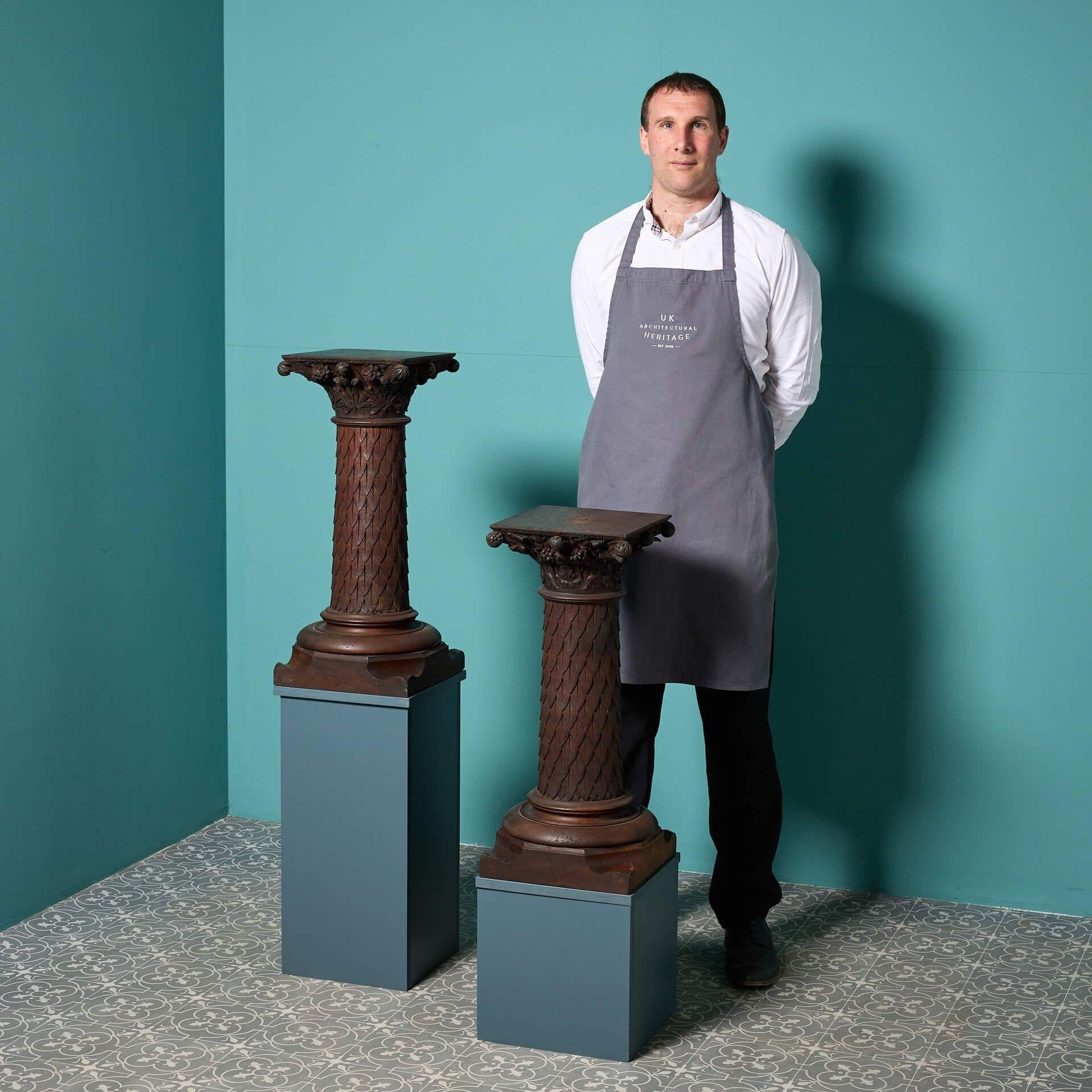 A pair of turned and carved oak column pedestals dating to circa 1900.

Styled foliage and floral designs to the centre, these large scale, rich colour and appealing finish makes each oak bracket a stunning architectural element of an interior.
