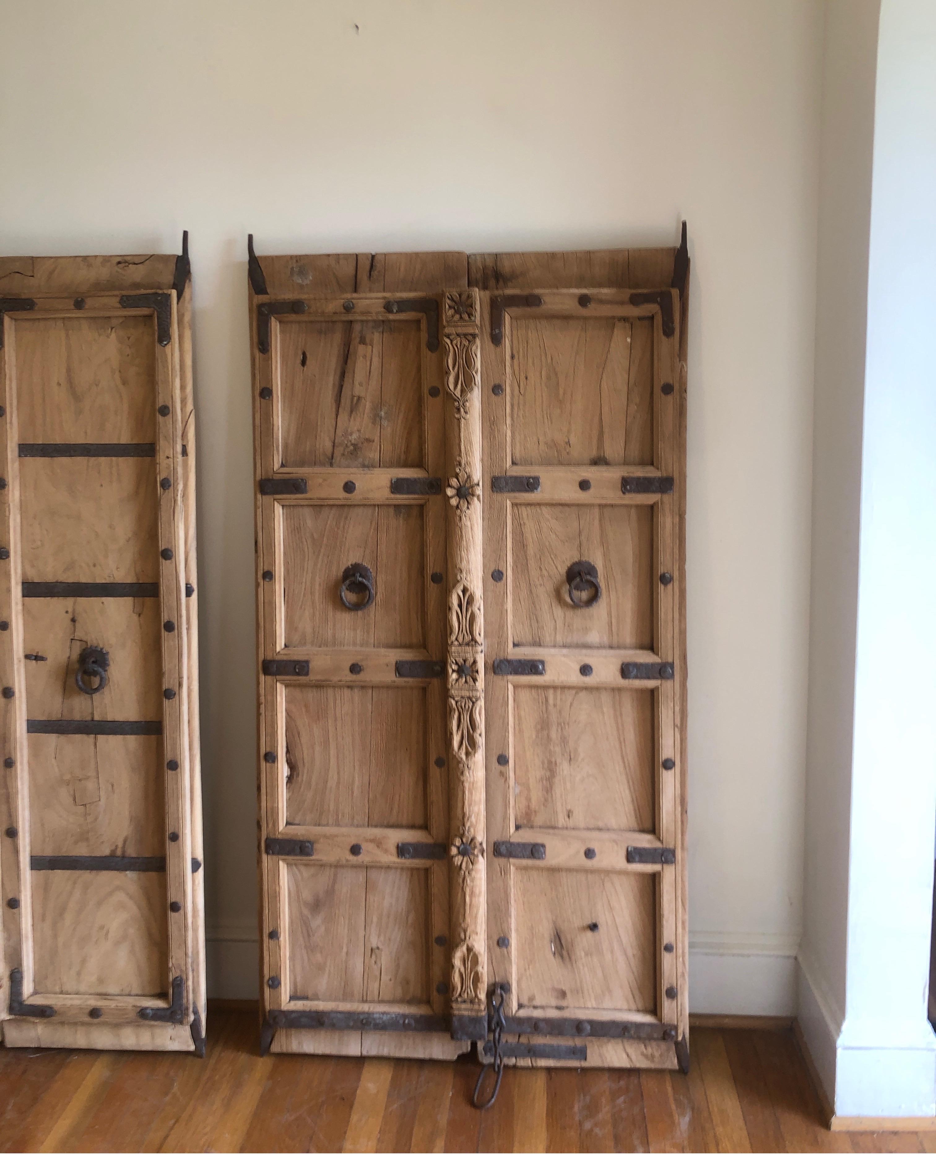 Listing as a pair/set, but we have separate listing for individual pieces, as well.
Hand crafted Teak door in early 20th century. Industrial metal details.
These are salvaged doors that have been barred together to make one larger door/Gate.