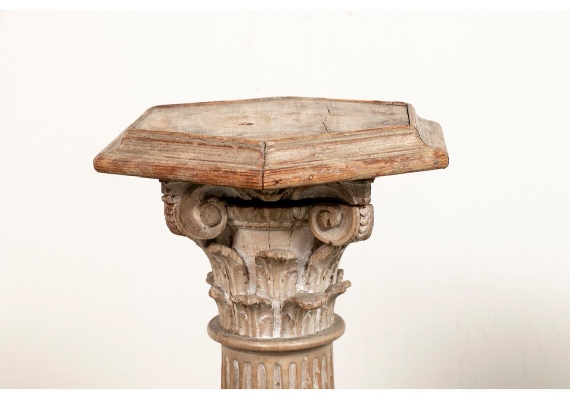 Elaborately carved fluted Corinthian columns with scrolled and leafy capitals. Raised on tiered square bases and mounted with hexagonal tops and weighted iron base attachments.
Measures: Height 40 3/4