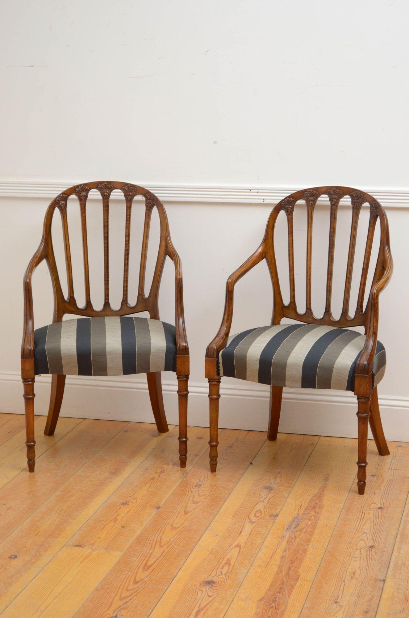 Sn5352 Fine antique elbow chairs in walnut, each having arched top rail with fleur de lis carvings, open arms and generous newly recovered seat, standing on turned and tapered legs. This antique pair of chairs retains its original finish which has