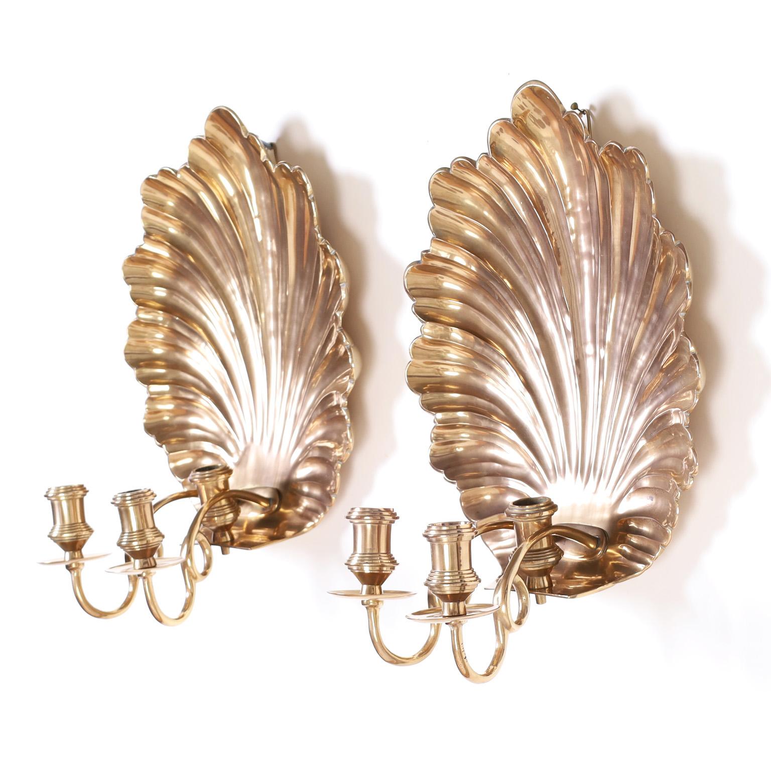 Standout pair of British colonial wall sconces with cast brass seashells and three turned brass candle cups. Hand polished and lacquered for easy care.