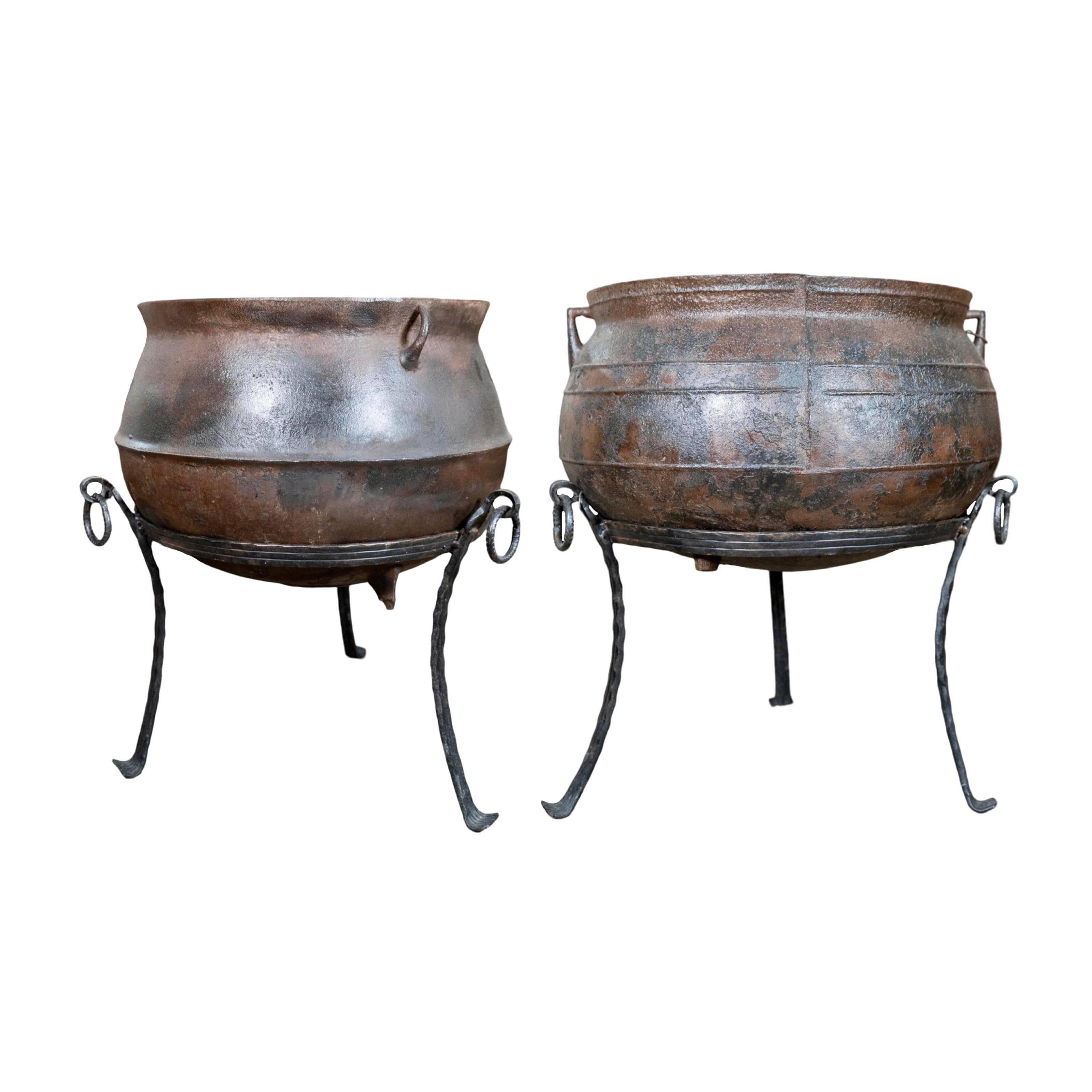 A stunning pair of 19th century antique cauldron-style planters, crafted from durable cast iron and imported from France. Sold as a set, each planter is elegantly designed with a distinctive tri-stand base, combining timeless charm with functional