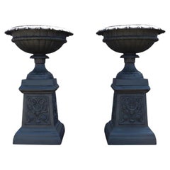 Paire d'urnes de jardin anciennes en fonte avec socles à motifs floraux stylisés, vers 1900