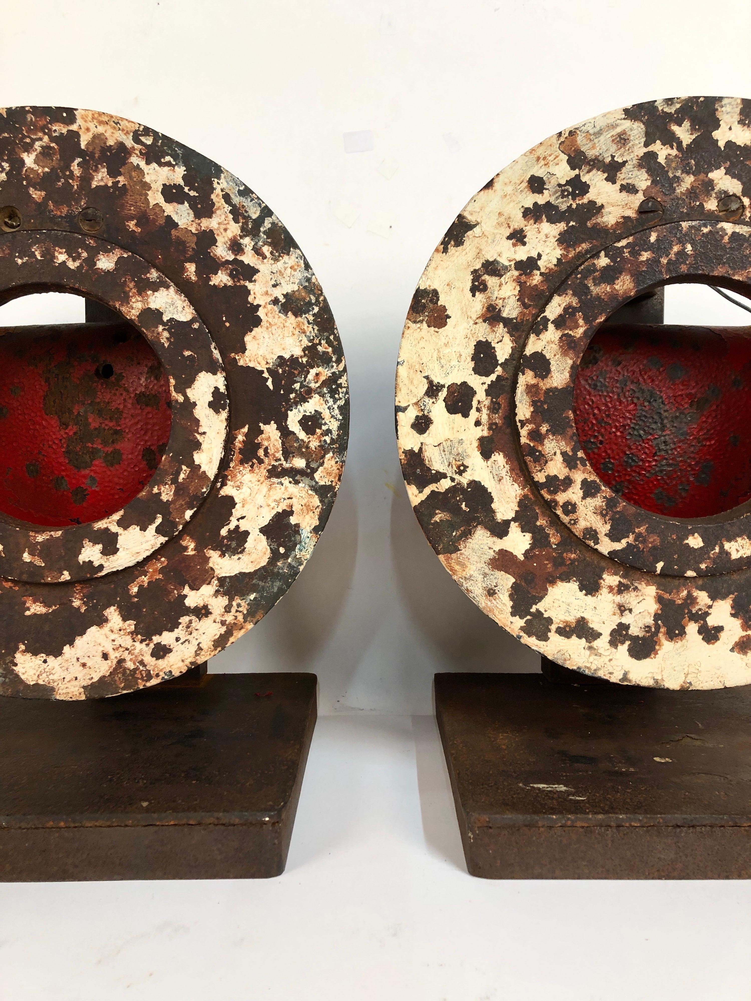 A matching pair of antique cast iron shooting gallery targets with original untouched surface. Great contrast in white paint against shot marks and rich red colored strike plate. Each one weighs 30 pounds. Very graphic pair.