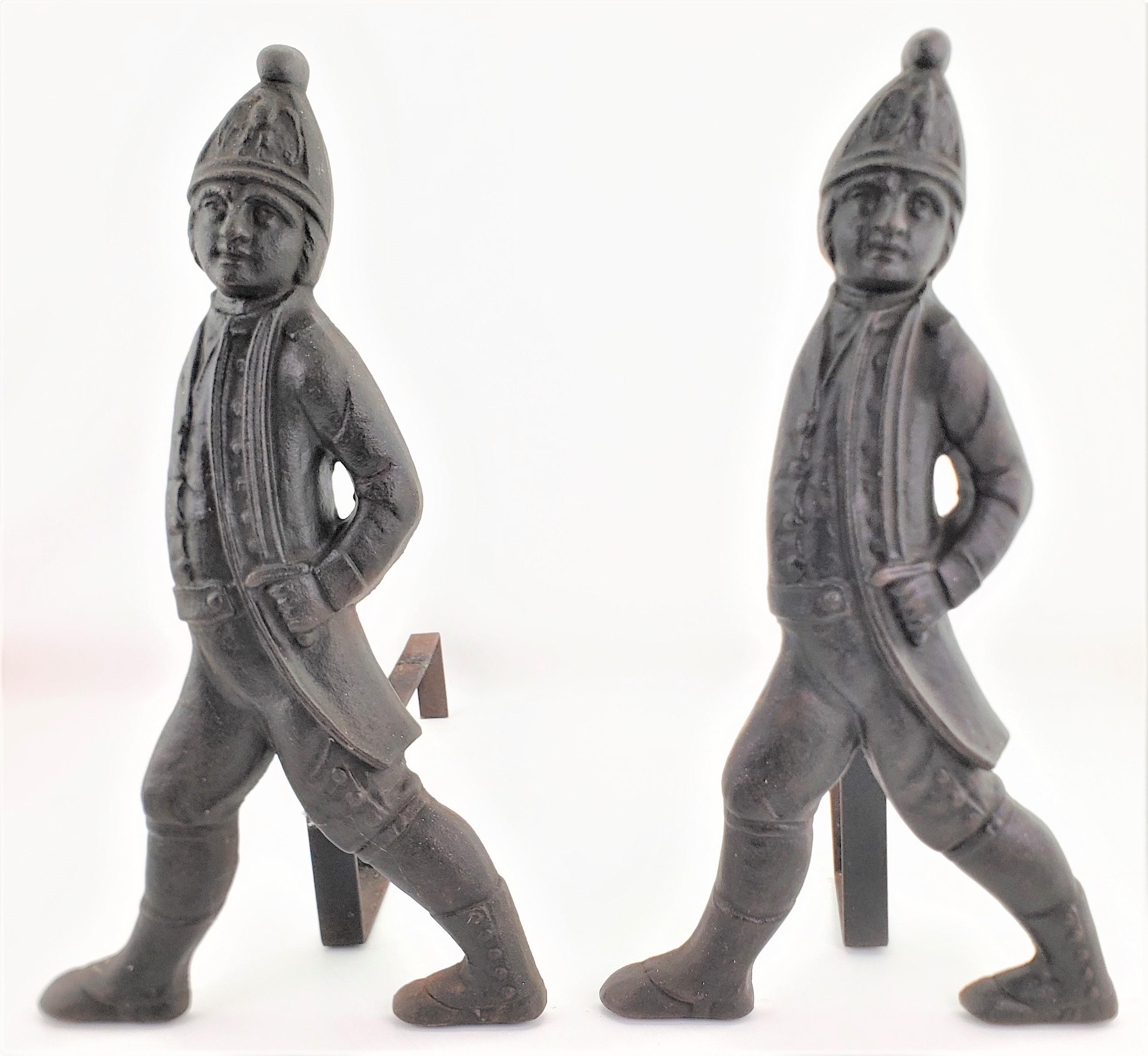 This pair of antique cast metal andirons are unsigned, but likely originate from Europe dating to approximately 1880 and done in the period Victorian style. The fronts of the andirons are cast figural soldiers in full regalia and are supported by