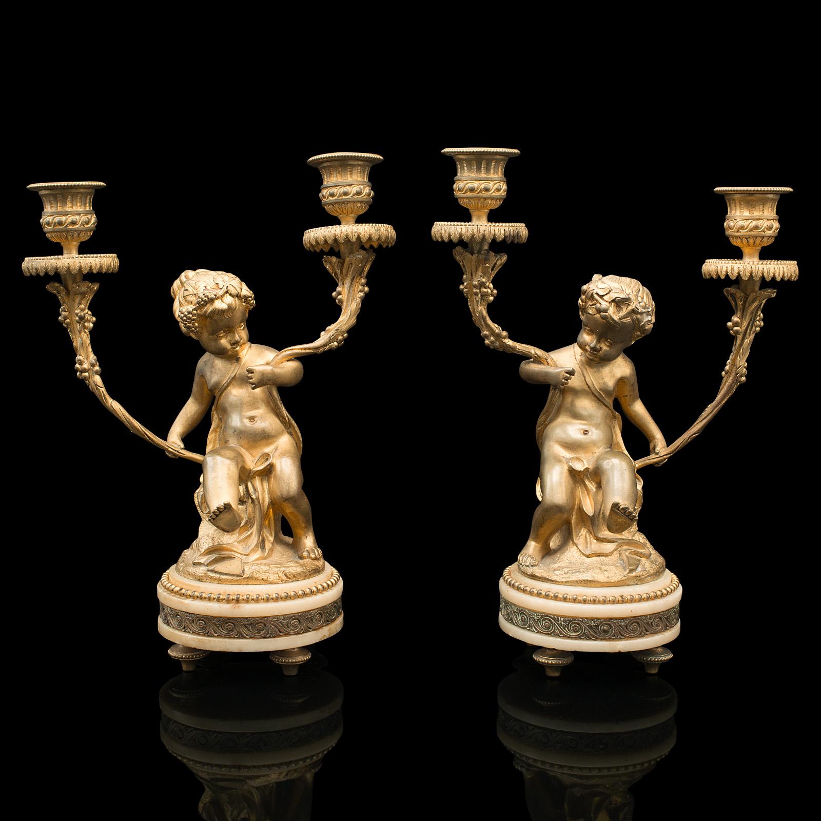 This is a pair of antique cherubic candlesticks. A French, gilt and onyx decorative candle stand, dating to the Victorian period, circa 1880.

A wonderful table-setting pair with striking colour
Displaying a desirable aged patina and in good