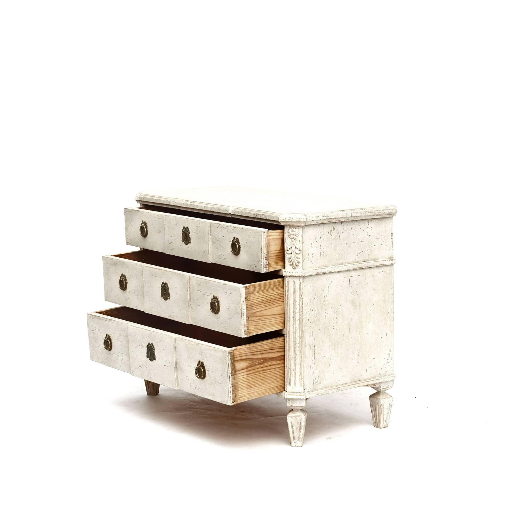 Pair of chests of drawers Gustavian style.
Top plate with edge profile strip under tooth cut.
Light gray painted chests features 3 breakfront drawers flanked by canted sides.
Rectangular top with canted corners in the front, sitting above a carved