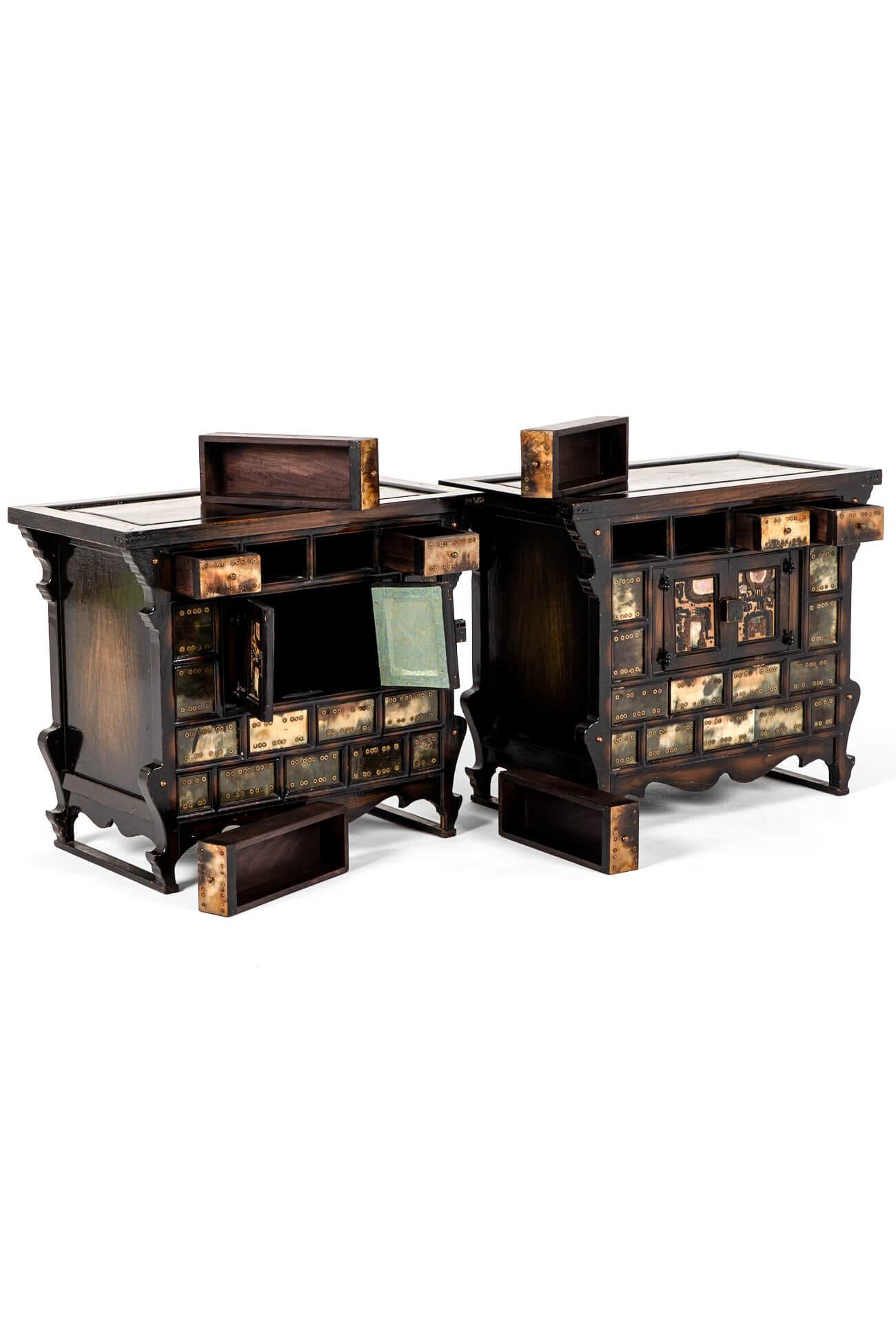 A wonderful pair of Chinese table top apothecary cabinets in elm with tortoiseshell coloured and enamel  decoration.

The spacious over sailing molded tops beneath a configuration of four long drawers each complemented with small brass handles to