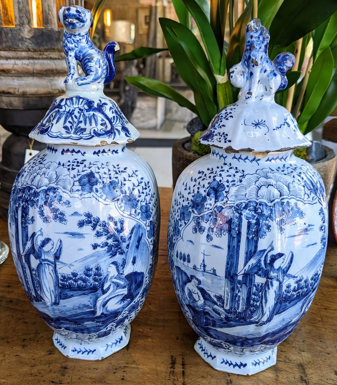 Stunning pair of antique European Chinoiserie jars featuring imagery depicting an angel pointing toward the Heavens (possibly Dutch made in Holland). Created from porcelain with glazing, and hand painted with a unique scenery. The gorgeous blue and