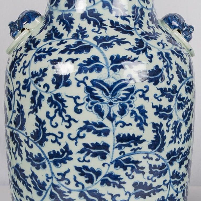 This exquisite pair of Chinese blue and white porcelain vases have an overall scrolling vines design. 
Around the base are lotus panels. A band of ruyi-shaped floral patterns adorns the top of each vase. 
Two lion-head handles are attached to each