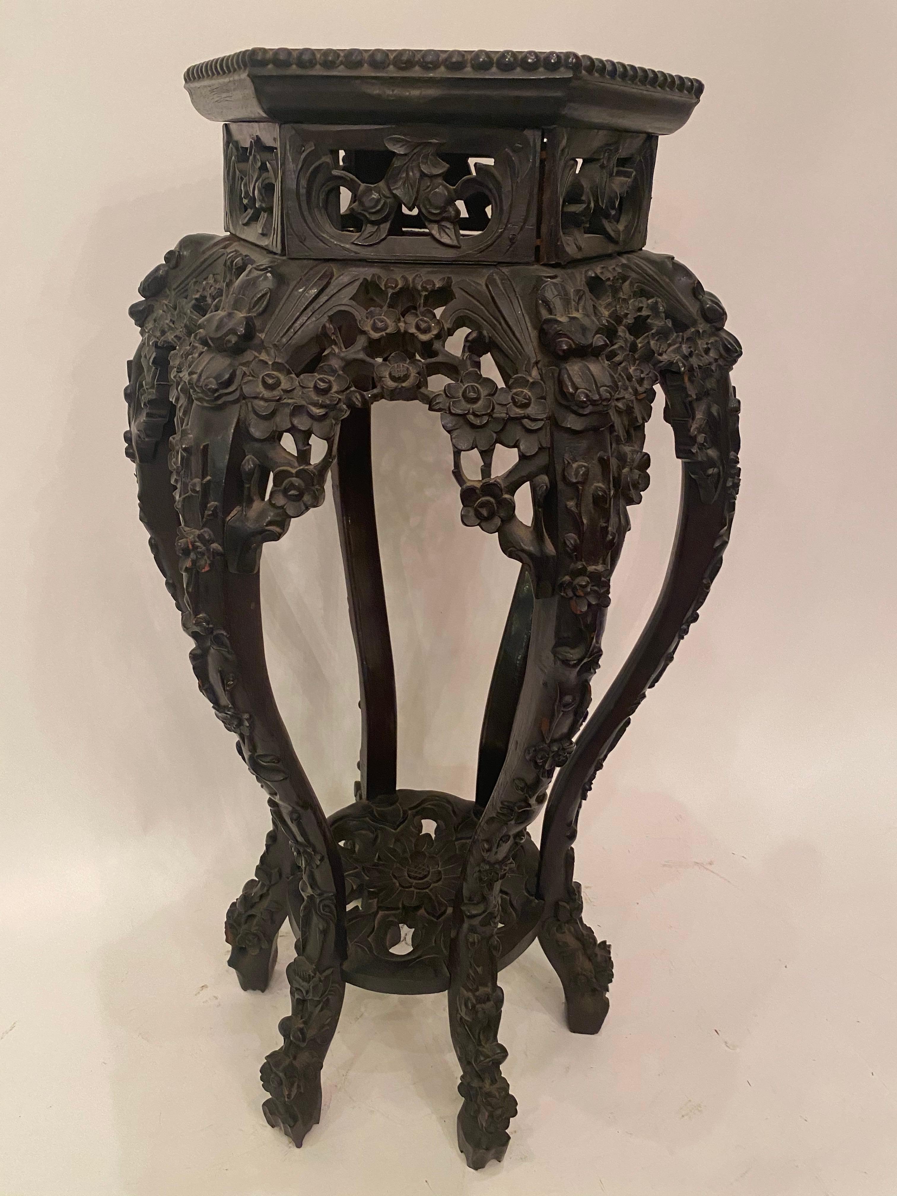 A pair of antique Chinese hardwood stands 6 sides marble top insert, 2 pieces, the inset marble top over carved rosewood apron with dogwood design and dragon shoulders with a caved floriform undershelf, one is taller and one is smaller, the small