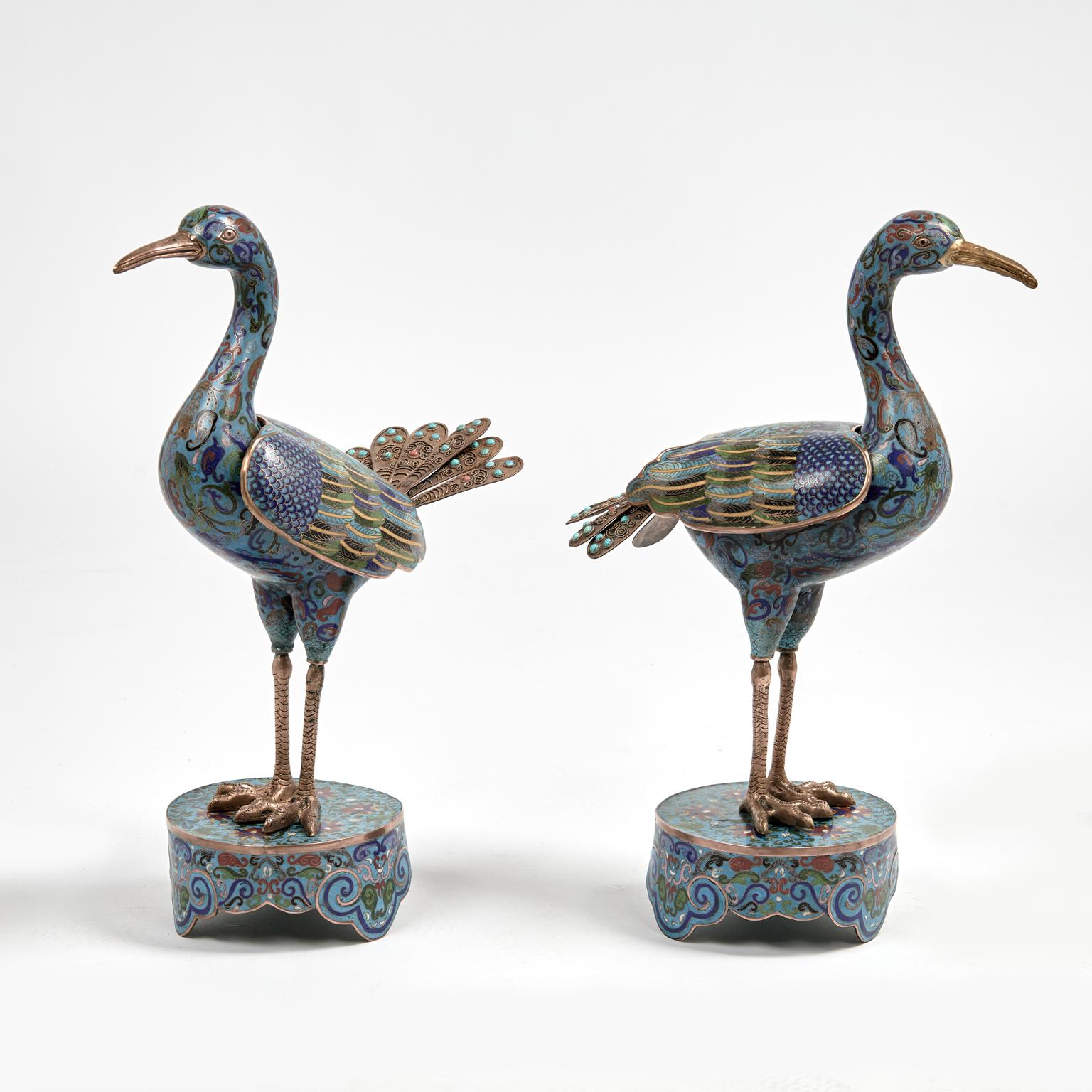 Coppia di uccelli cinesi realizzati a mano in ottone e decorati in cloisonne con disegni floreali e simbolici su un seducente sfondo blu, con piume di coda stilizzate in ottone decorate con pietre semipreziose e ali rimovibili come una scatola con