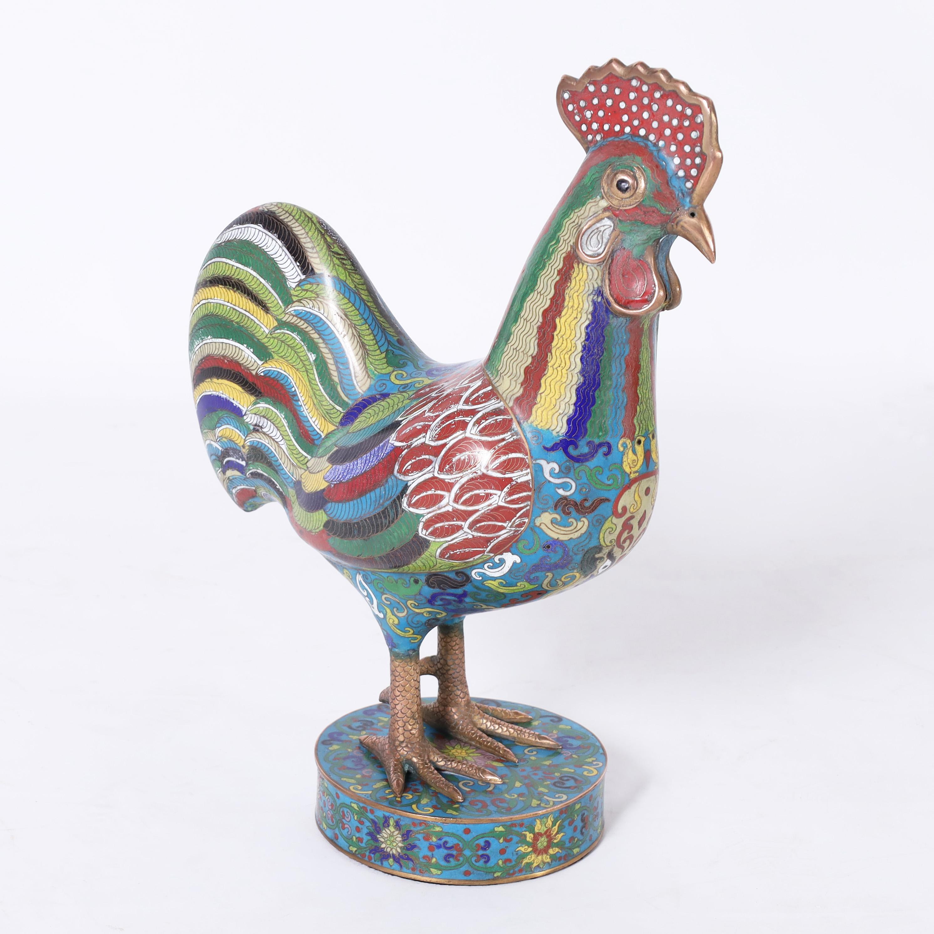 Stand out pair of antique Chinese roosters handcrafted in enamel on copper or cloisonne in the traditional technique with bold colors of fauna and flora on a blue background.