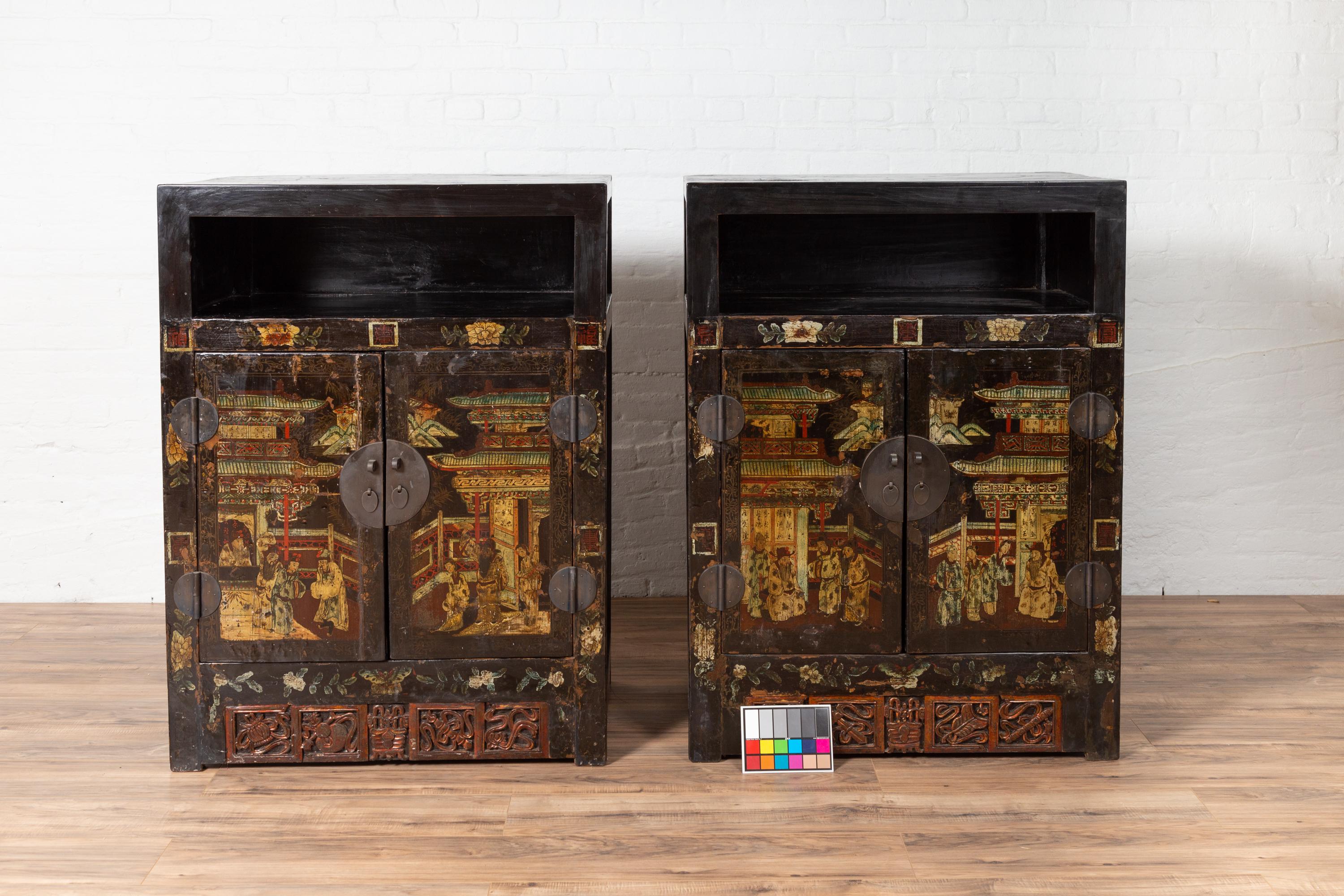 A pair of Chinese tall display cabinets from the 19th century, with hand-painted Chinoiserie décor depicting people and traditional architectures in a landscape. Born in China during the 19th century, each of this pair of display cabinets features