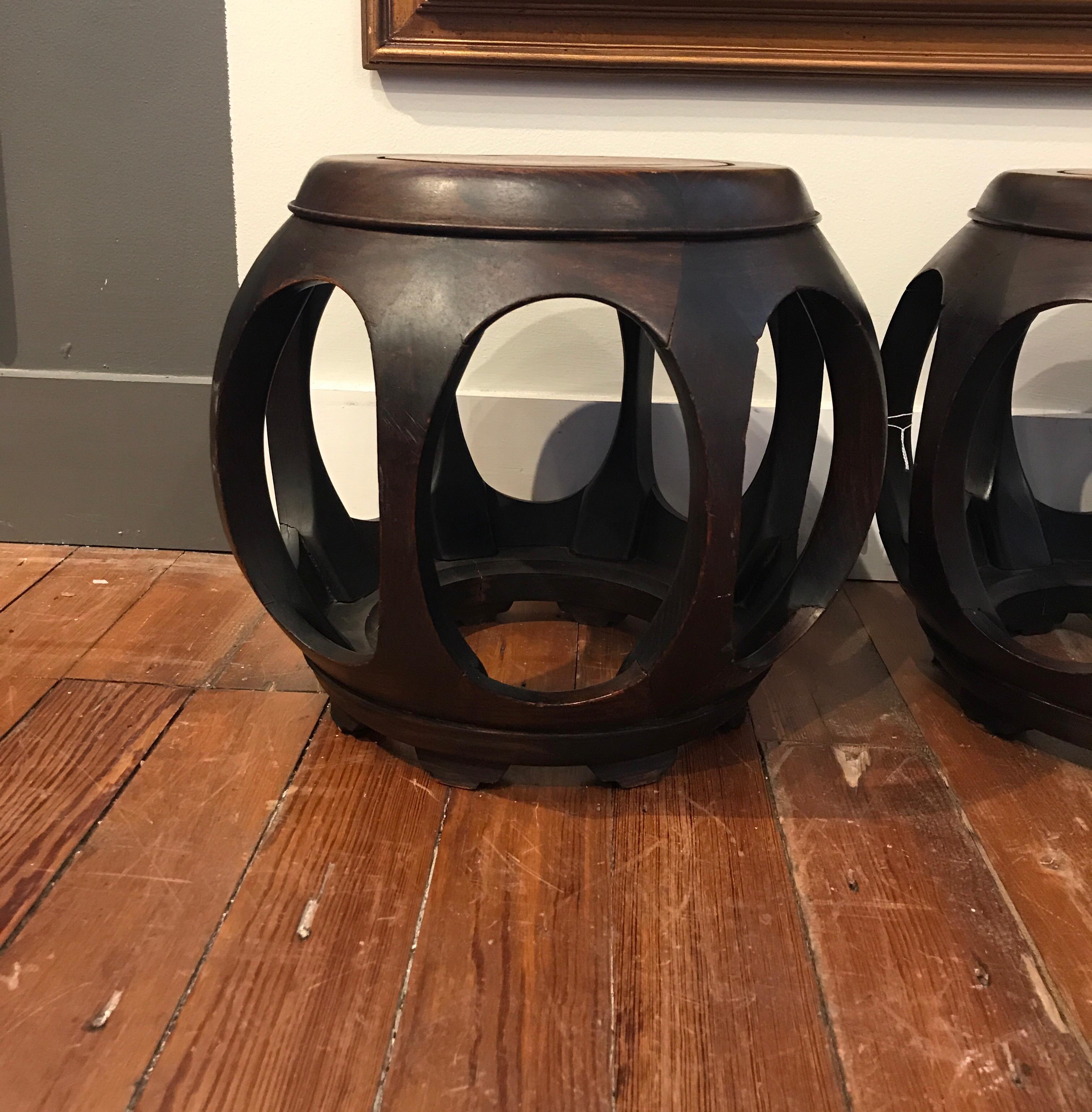 A great pair of antique Chinese hardwood stools or large vase stands in a barrel form. The oval openings all around with solid tops and open bases.