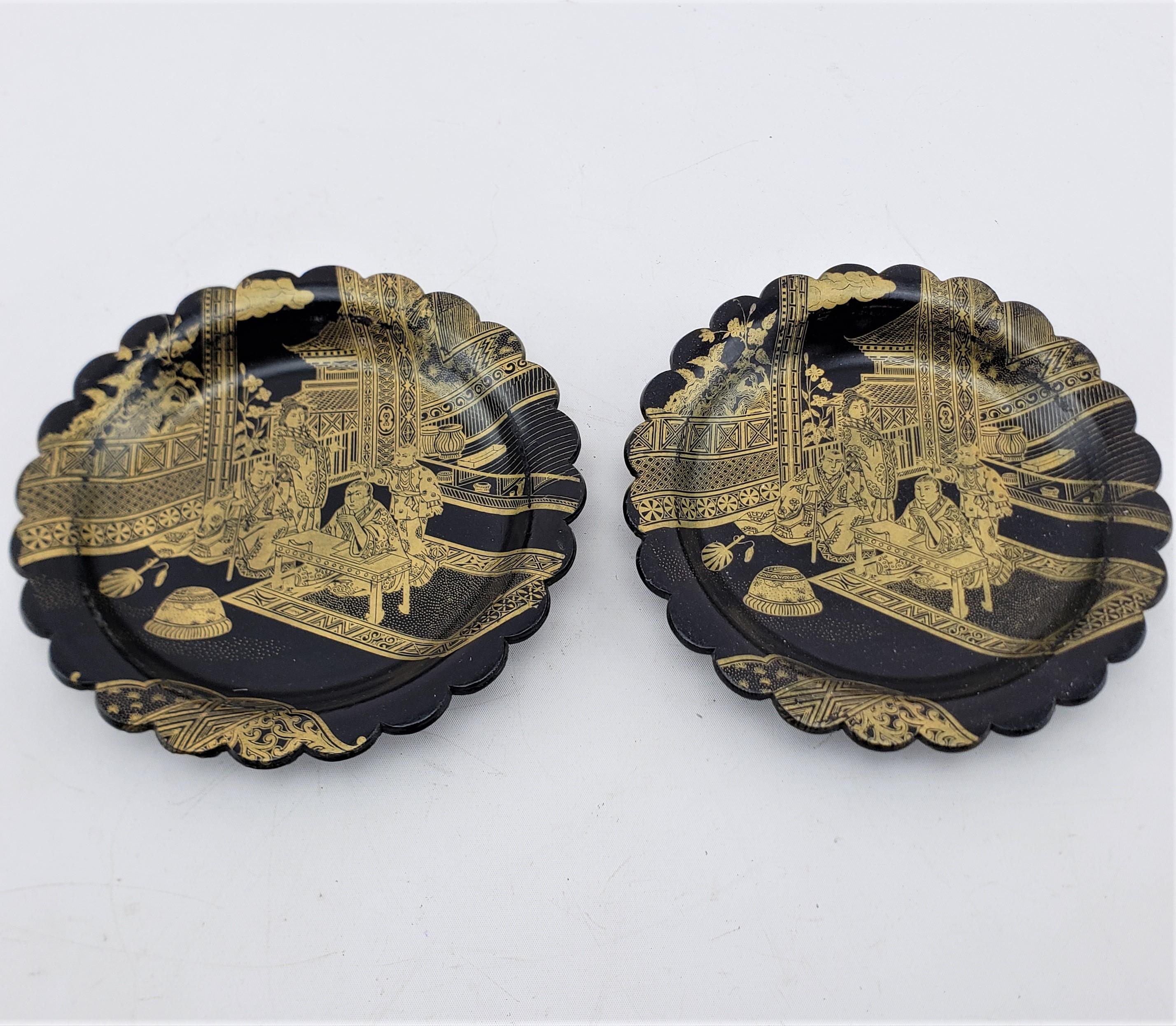This pair of antique bottle coasters are unsighed, but presumed to have originated from China and date to approximately 1920 and done in the period Chinese Export style. The coasters are composed of paper mache with a ebonized finish and decorated