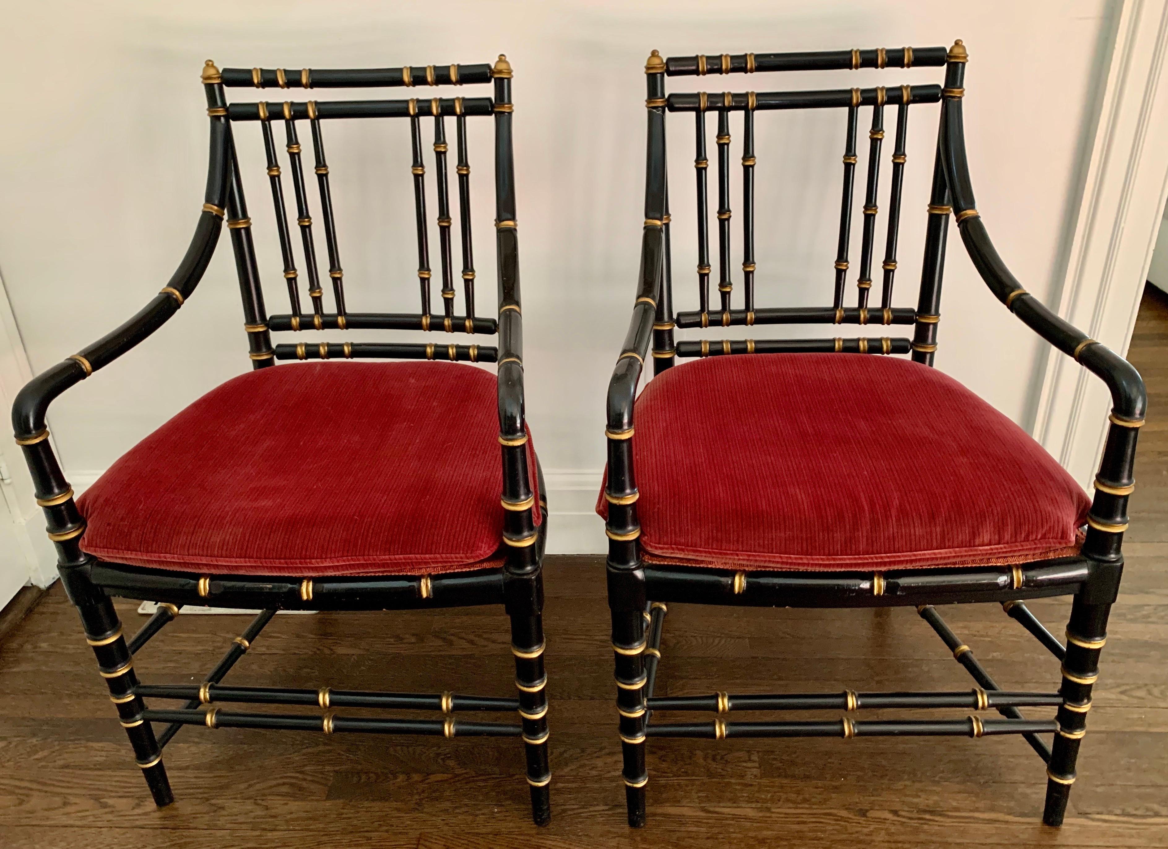 Pair of Chinese Chippendale faux bamboo black armchairs with gold gilt detail and beautiful red velvet seat cushions.