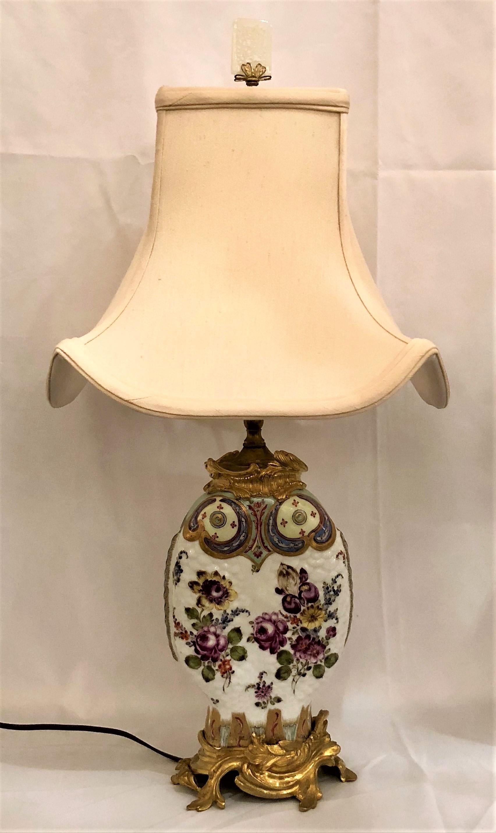 Pair of antique chinoiserie porcelain lamps with ormolu mounts. Possibly Samson. These are very charming with their fish motif and rippled surface as if scales of the fish.