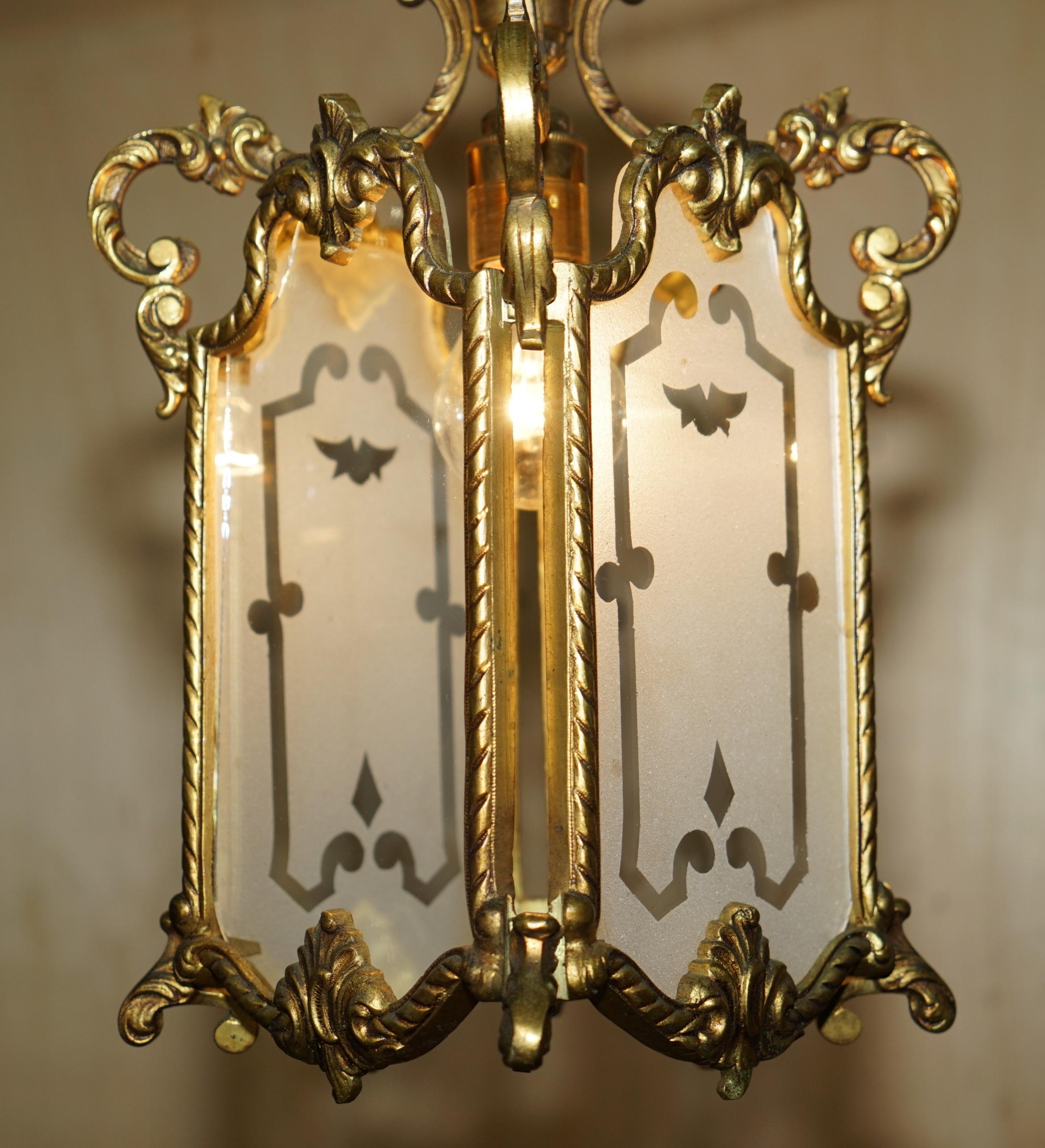 Français PAIR OF ANTIQUE CiRCA 1920 POLISHED BRASS HANGING LANTERNS WITH FROSTED GLASS en vente