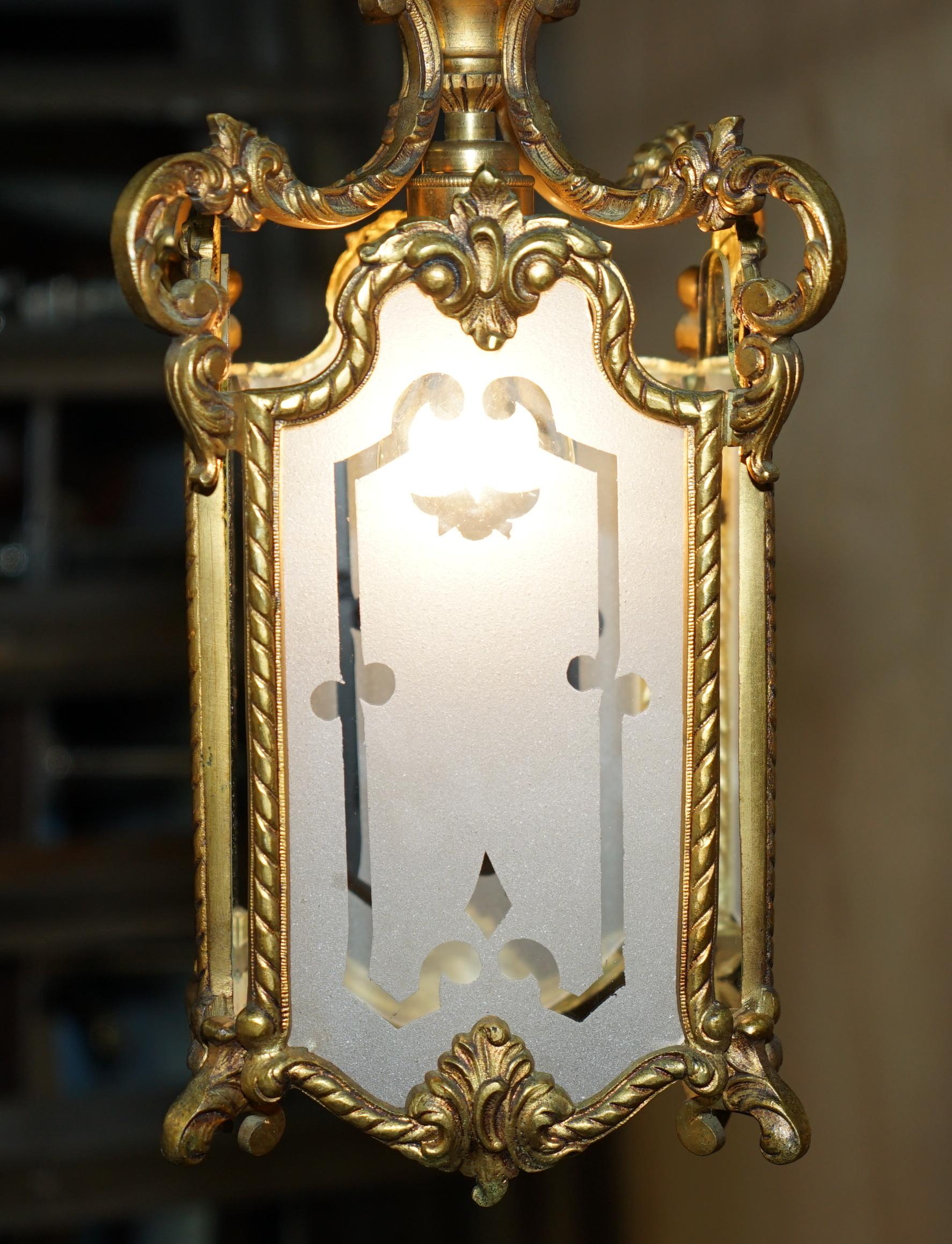 Laiton PAIR OF ANTIQUE CiRCA 1920 POLISHED BRASS HANGING LANTERNS WITH FROSTED GLASS en vente