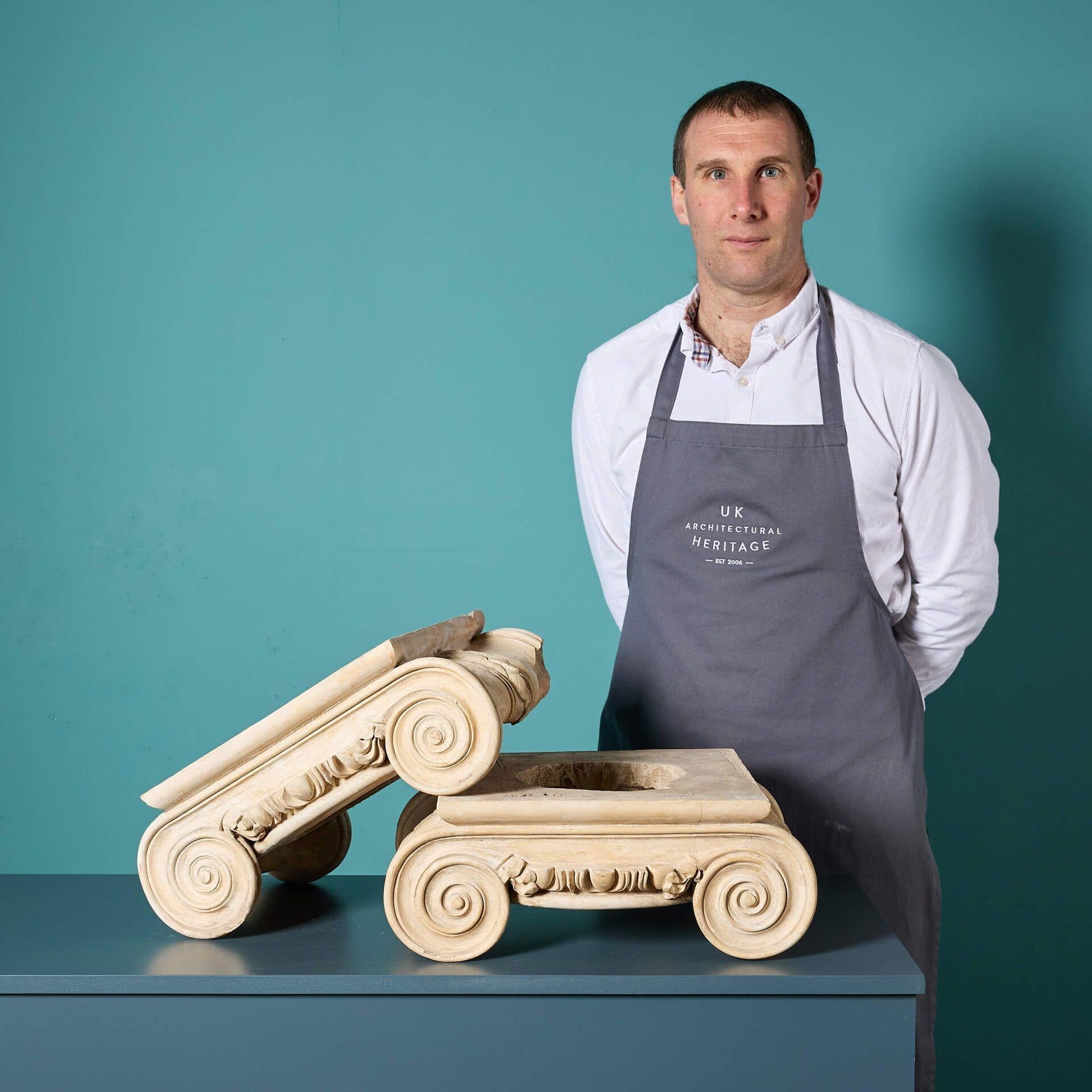 A pair of antique architectural capitals attributed to renowned English stone manufacturer Eleanor Coade.

Dating to circa 1860, this pair of decorative ionic capitals are a fragment from architectural history, preserved through time for more than