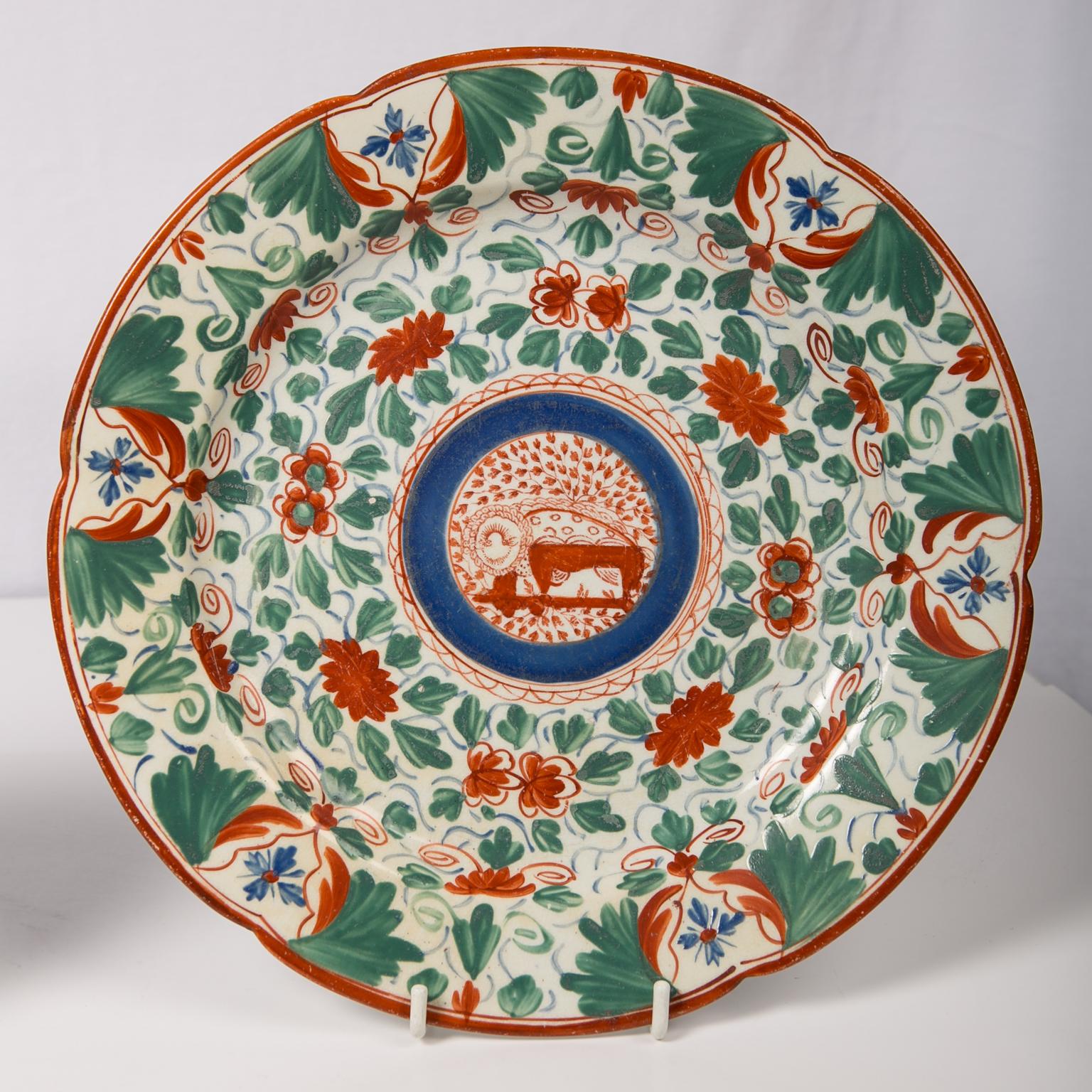 We are pleased to offer this pair of antique pearl-glazed creamware dishes hand painted in bright colors featuring a dragon like mythical animal in the central rondel. Made in England by Minton circa 1810 this is a lively, whimsical pattern which