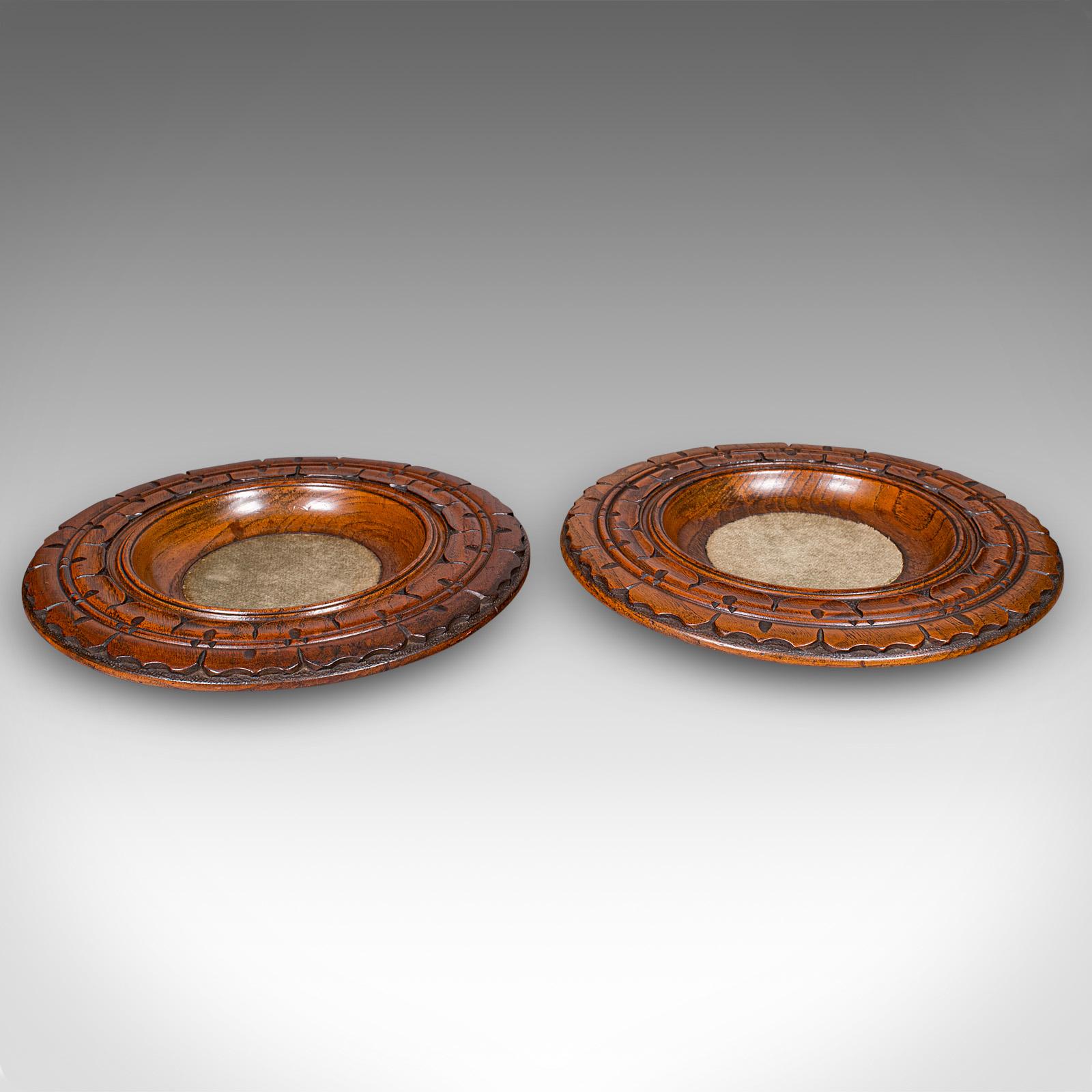 This is a pair of antique decanter coasters. An English, carved elm wine or champagne bottle stand in Gothic revival taste, dating to the late Victorian period, circa 1890. Handsome examples of Gothic-inspired woodcraft with fine detail and superb