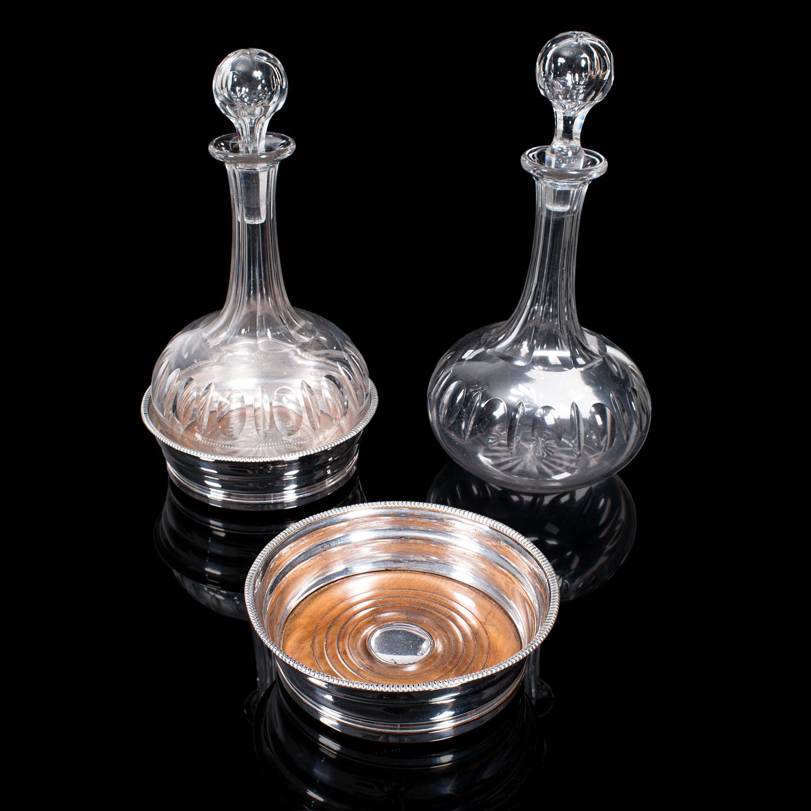 This is a pair of antique decanters with stands. An English, glass vessel and silver plate coaster, dating to the Edwardian period, circa 1910.

Delightfully presented decanters with quality stands
Displaying a desirable aged patina and in good