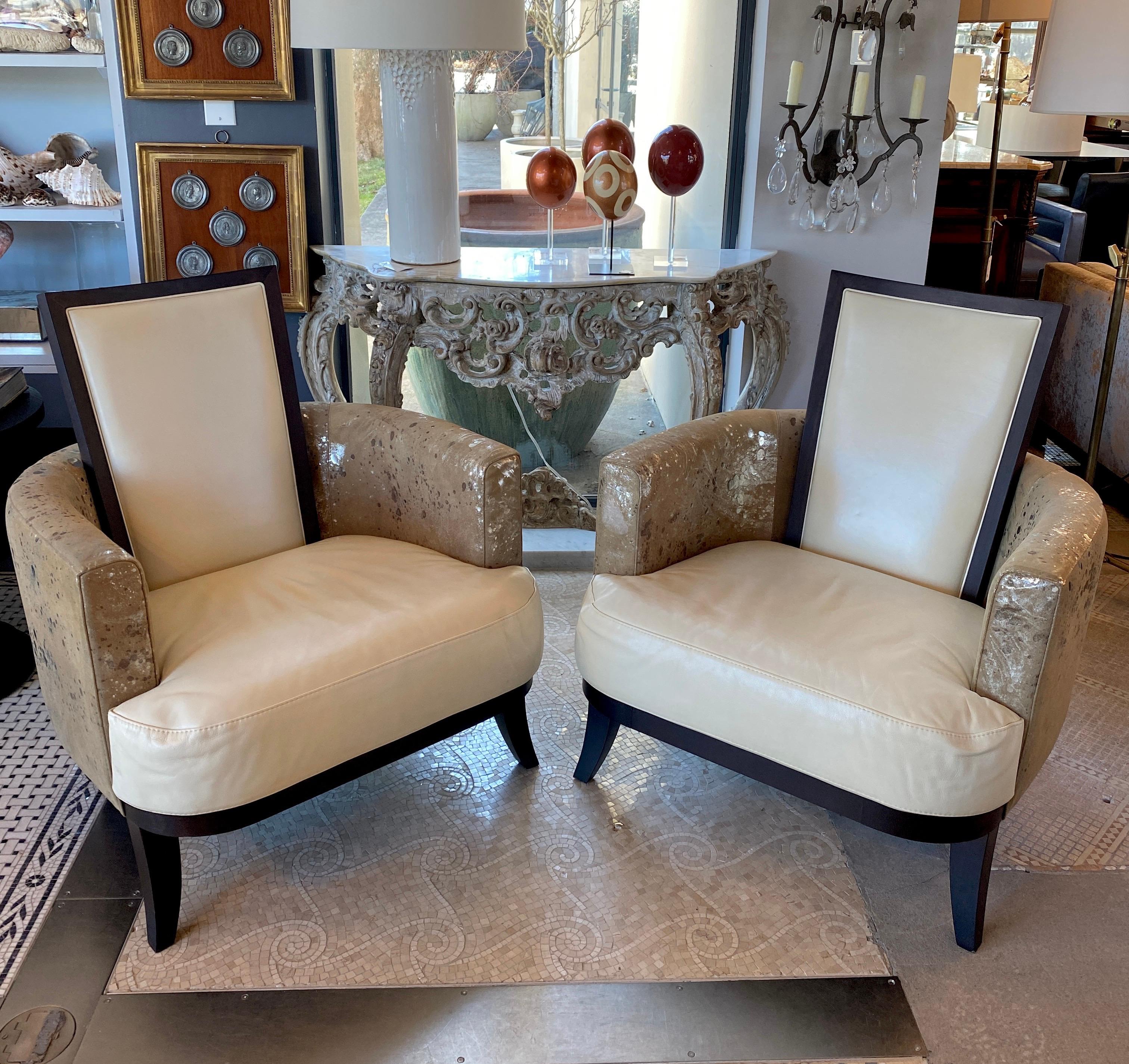 Pair of antique deco two tone chairs 

Cream colored leather paired with a metallic gold and silver fabric, and deep dark wood chair legs.