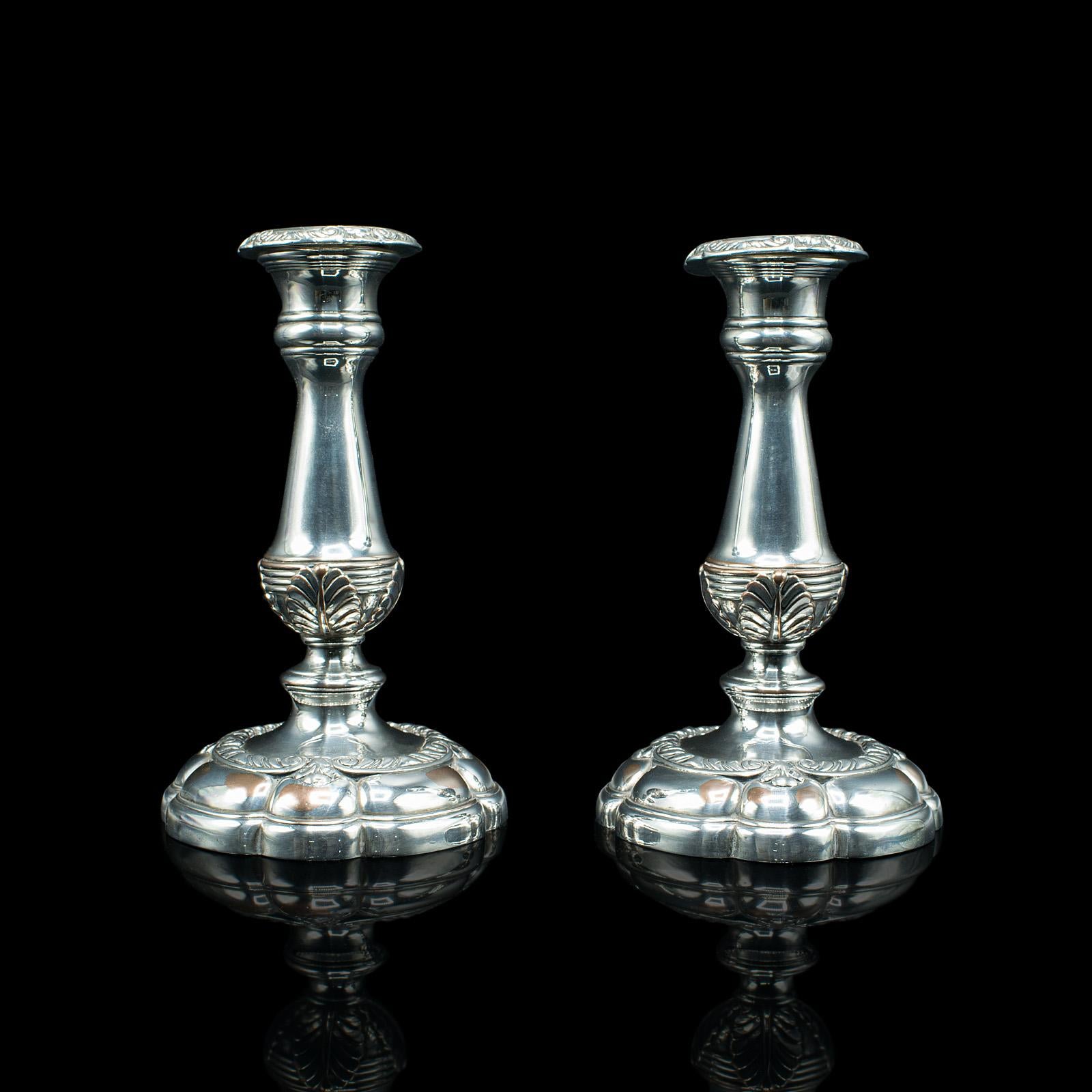 This is a pair of antique decorative candlesticks. An English, silver plated mantle or dinner table candle stand, dating to the Edwardian period, circa 1910.

Pleasingly decorative and brightly polished candlesticks
Displaying a desirable aged