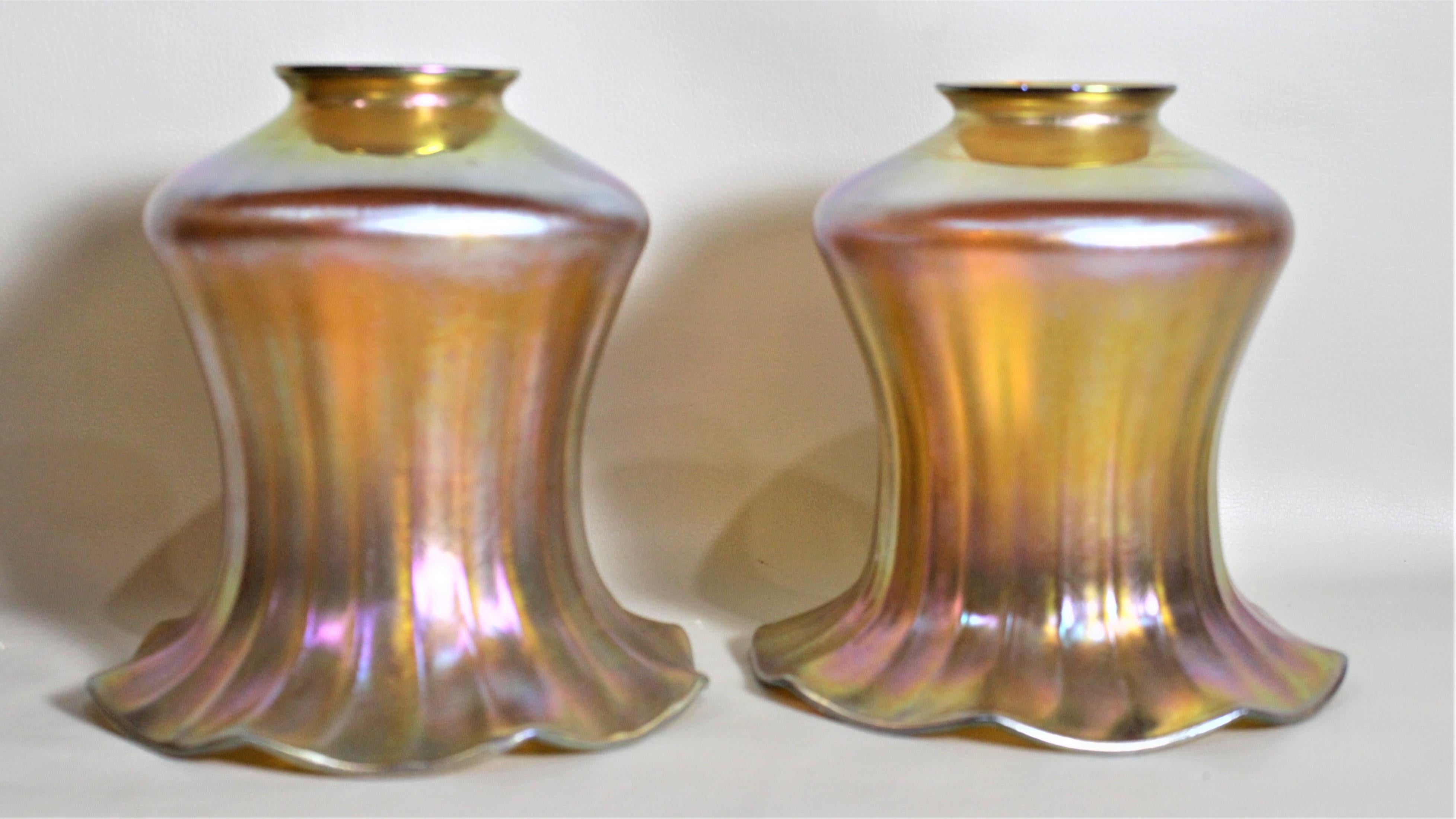 Cette paire d'abat-jour en verre d'art ancien n'est pas signée, mais on suppose qu'elle a été fabriquée en Bohemia vers 1880 dans le style victorien de l'époque. Les abat-jour sont en verre d'art marigold profond avec une forte irisation, des côtés