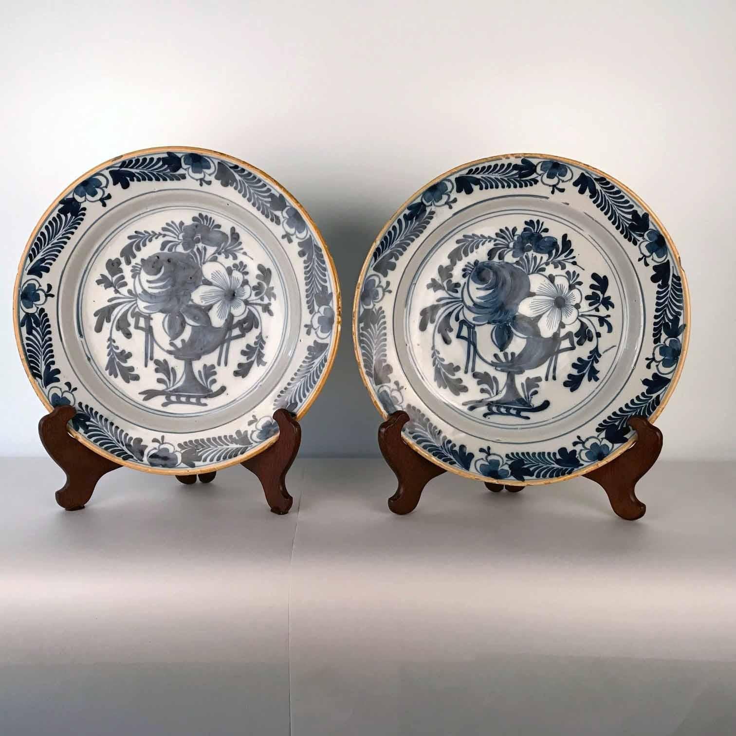 This large pair are each freely painted with a vase of flowers and fruit in the traditional blue pallet. the edge has minor frittings as is inevitable. other than this they are in very good condition.