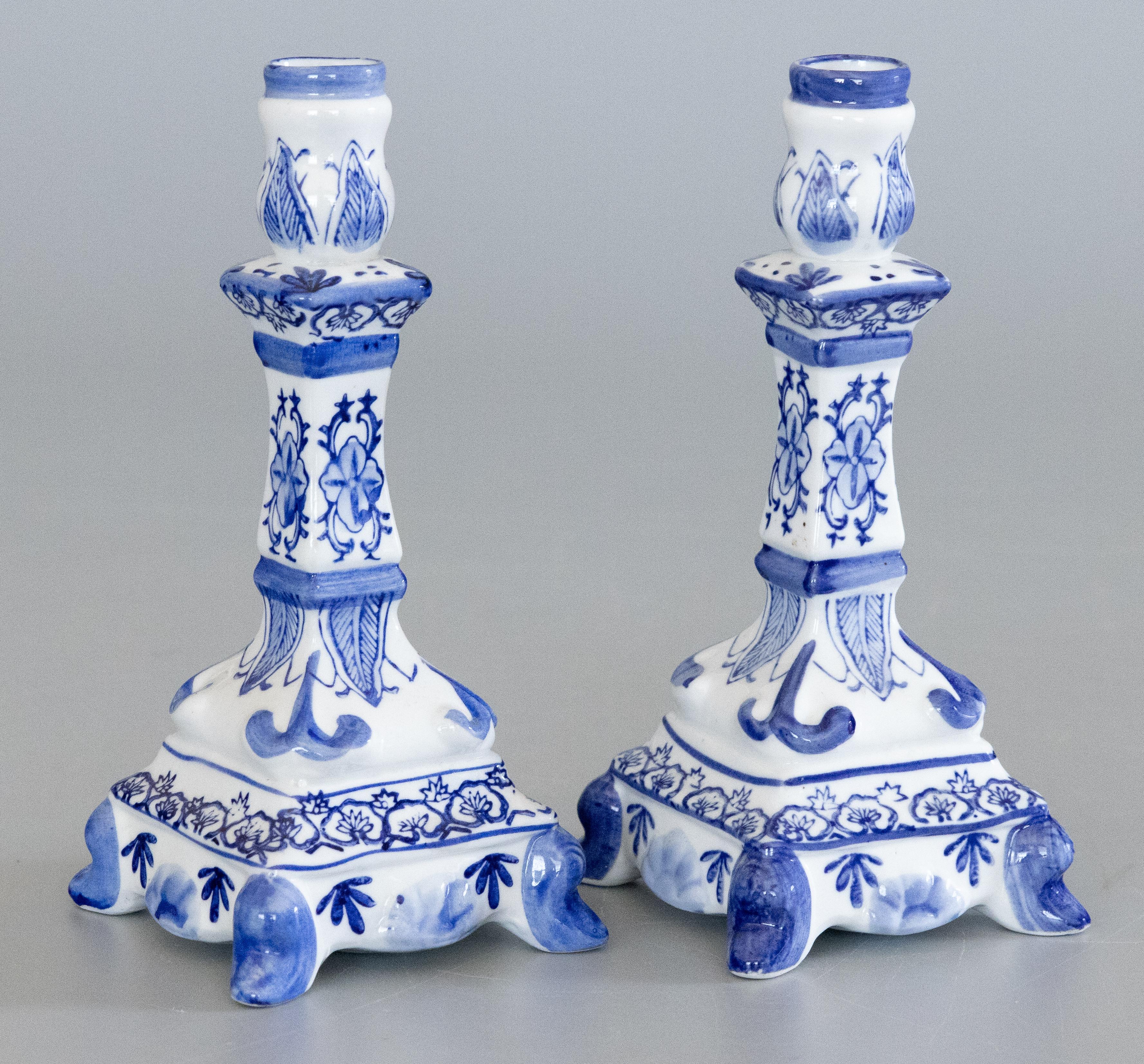 A lovely pair of antique early 20th Century Dutch Delft candlesticks, unmarked. These fine candlesticks are decorated with a hand painted beautiful floral design in the traditional Delft colors of cobalt blue and white. 