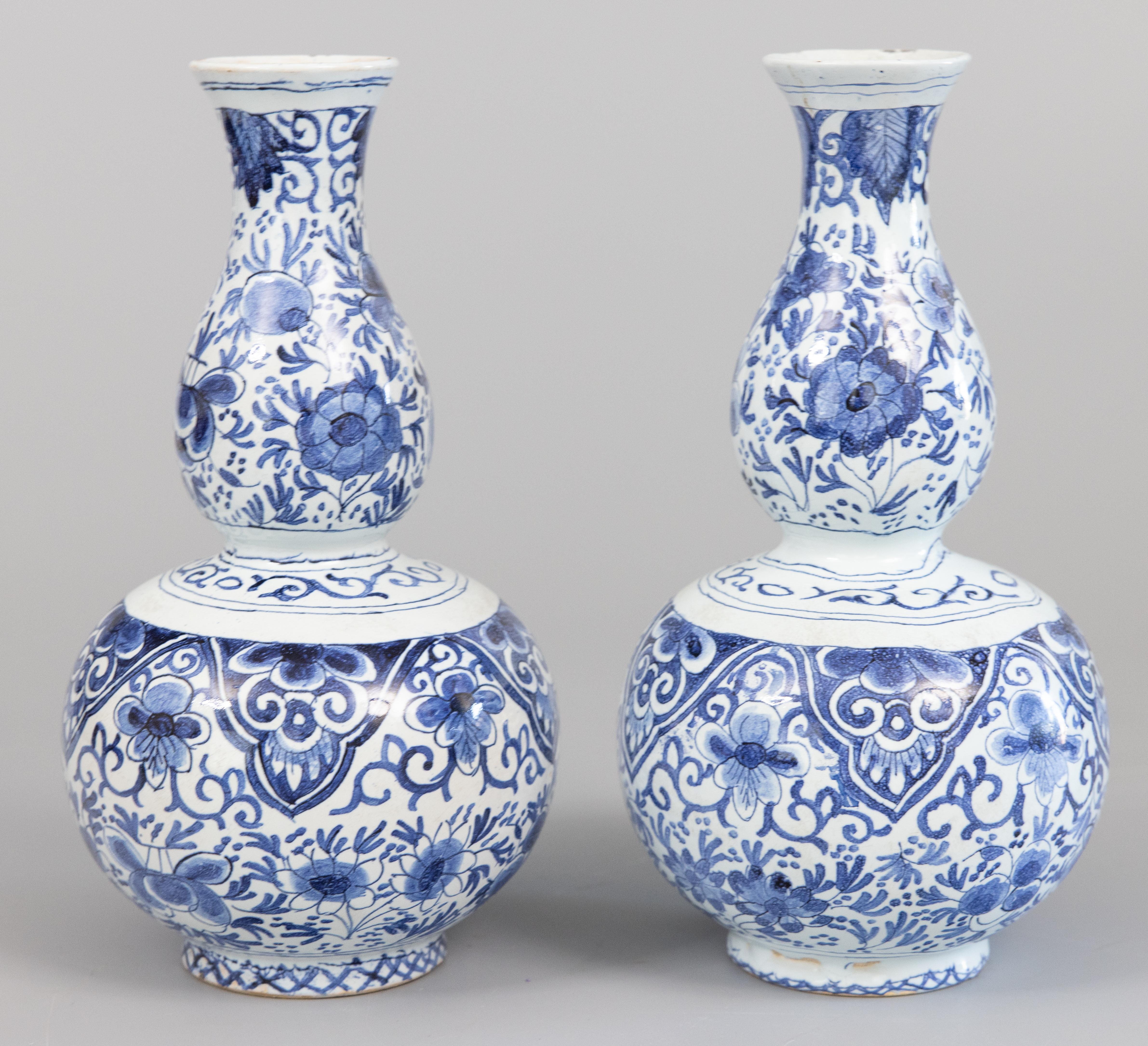A superb pair of antique Dutch double gourd Delft faience vases, circa 1800. Maker's mark on reverse. These lovely very collectible vases are both hand molded and hand painted with finely detailed floral designs in cobalt blue and white. They have