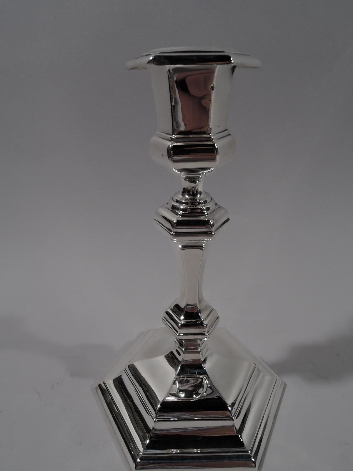Pair of Edwardian Georgian sterling silver candlesticks. Made by Gorham in Providence in 1906-1907. Each: Bellied socket with stepped and detachable bobeche; knopped shaft and stepped foot. Faceted form works well on Modern table settings, too.