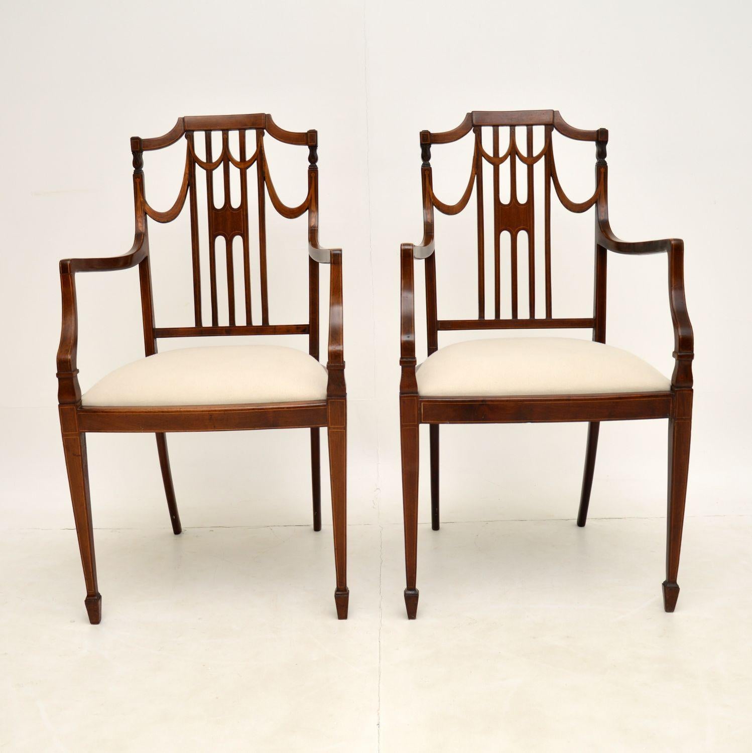 A stunning pair of antique Edwardian period armchairs in mahogany. These were made in England and date from the 1900-1910 period.

They have a very elegant design, with sweeping arms, a beautifully pierced back and tapered legs terminating in
