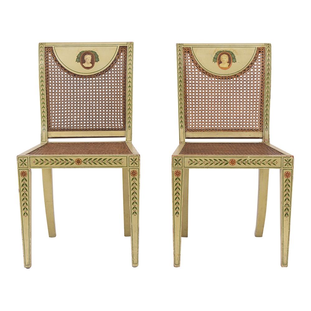 This pair of Late 19th Century Edwardian style Chairs are in good condition and features the original hand-painted floral and leaves pattern design. These side chairs are made out of solid wood, the seat & backrests have the original caning in good