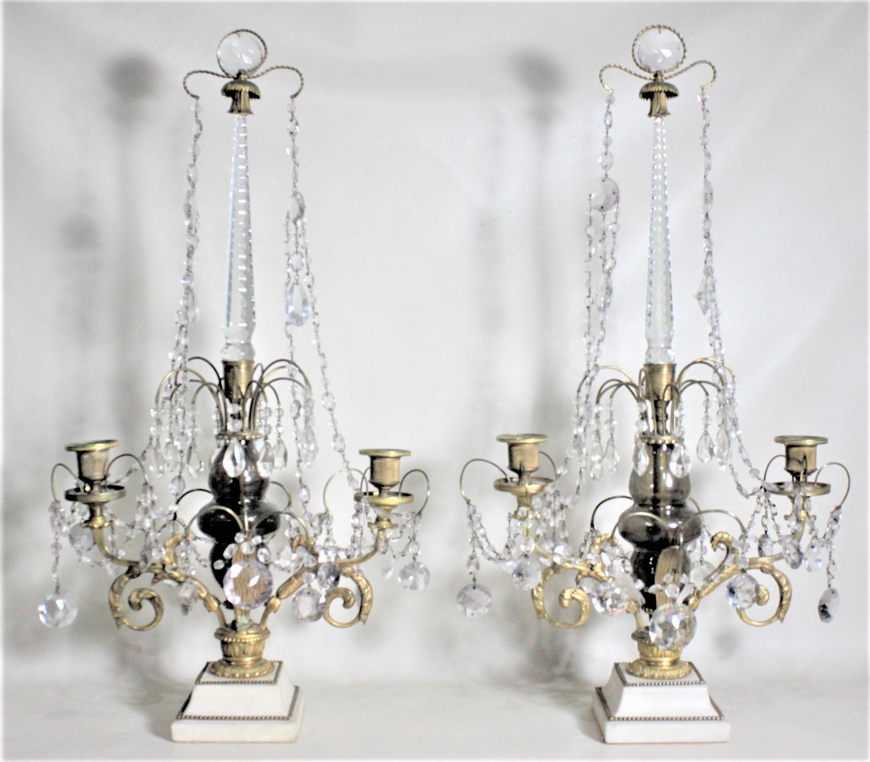 This pair of quite large and substantial antique bronze and crystal candelabras show no maker's marks, but are presumed to have been made in France in circa 1920 in the Renaissance style. Each candelabra has nicely executed cast and gilt bronze arms