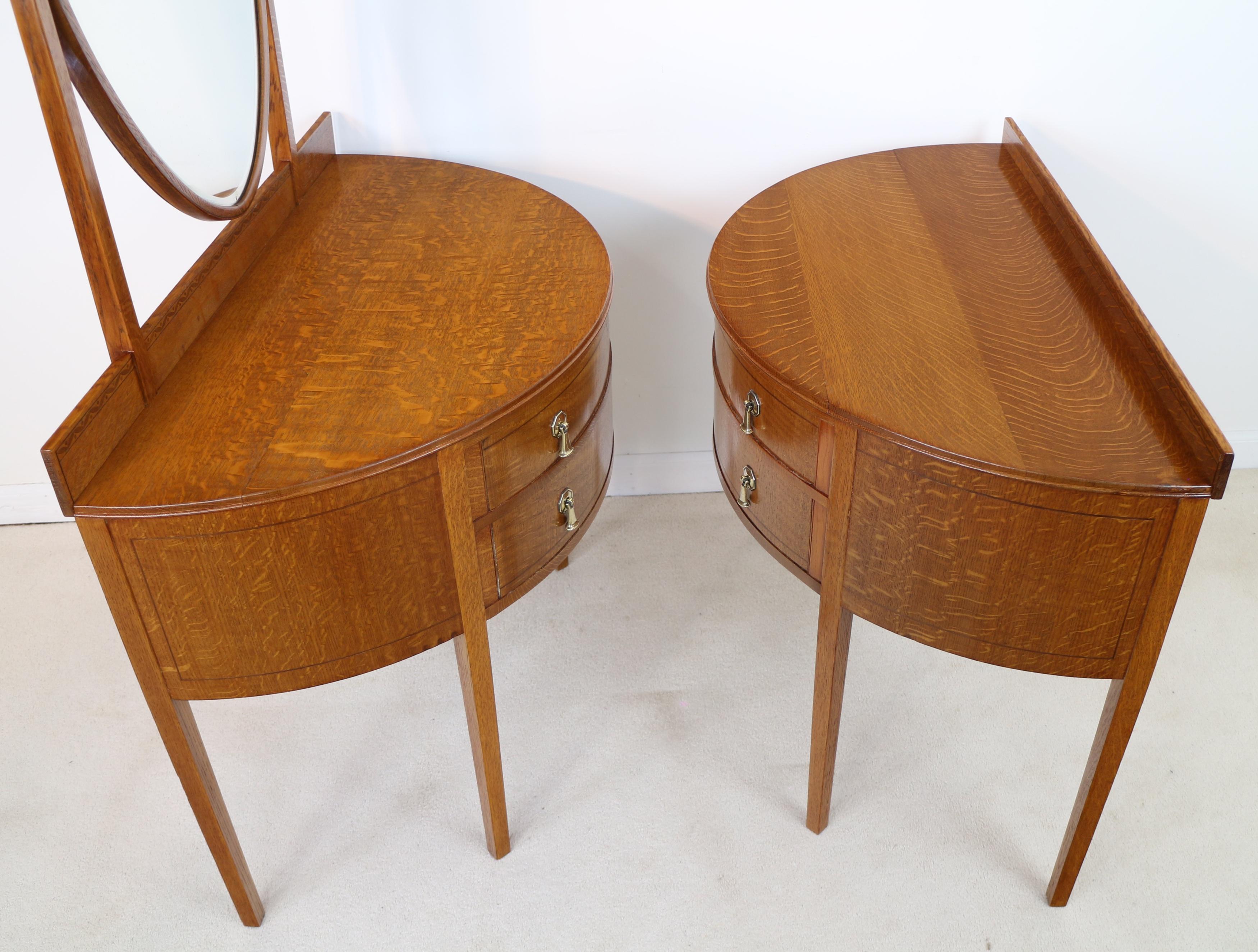 A super pair of Arts & Crafts oak and inlaid ladies & gents dressing chests by Shapland & Petter of Barnstaple dating to circa 1910. Each with demi-lune shaped thumb-moulded top and inlaid gallery back above two line inlaid drawers with brass drop