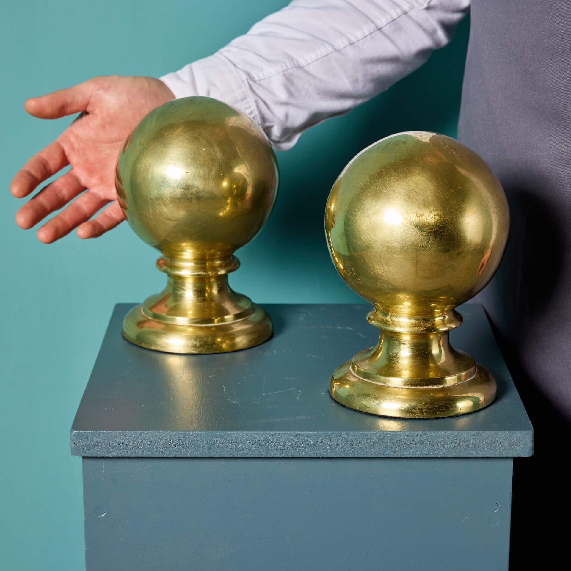 A pair of large antique English cast brass ball finials, salvaged from a stables in Newmarket, England.

With their bold brass colour and highly polished finish, this impressive pair of finials would make a striking display piece in any home,